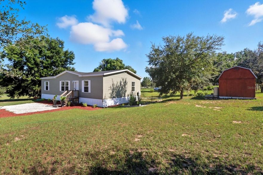 Located in adorable Floral City, halfway between Inverness and Brooksville, this 2022 doublewide is MOVE IN READY. Beautiful wood look vinyl floors give the great room a modern touch. The expansive kitchen has an apron sink and huge island with bookshelves and pillar legs, making it feel custom. The 10x20 shed sits on a slab, and there is plenty of space for your animal friends and anything else you'd like to add since there are no restrictions or HOA! The Rails to Trails bike path is just around the corner, and a great disc golf course at Floral City Park is a couple of streets over.