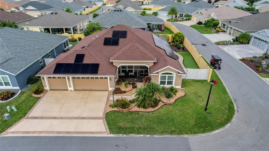 Welcome to this lovely 2019 built 4 bedroom 3 bathroom 3 car garage (29'4" x 22'9") home with upgrades galore in the Village of Monarch Grove. This home features an OUTDOOR PUTTING GREEN, solar panels (PAID OFF), whole house water filtration system as well as MAGIC STAIRS, an elevator storage lift in the garage and 2 solar fans & added shelving/flooring in the attic. Step inside to see beautiful tile floors in the main areas and premium laminate flooring in the bedrooms. The kitchen is a chef's dream with dark wood cabinets, gas stove, white quartz countertops, stainless steel appliances, island, breakfast bar, breakfast nook, and a cabinet pantry. The spacious primary suite offers a coffered ceiling, 2 walk-in closets, an en suite bathroom with two separate vanities, a Roman shower, and a water closet. The inside laundry room offers tons of storage and a utility sink. All three guest bedrooms offer tall ceilings and closets for storage.   In addition, One guest bedroom has a Murphy bed with attached fold-down desk for your family and friends. The massive FL room (38' x 9'6") with Mini-split is perfect for entertaining especially with the sliding doors that can be stacked so that you have a full view. The fully fenced backyard gives privacy while the patio area adds a great space to enjoy the beautiful outdoors while the screened front porch is a great place to enjoy your morning coffee. Located within easy reach of restaurants, shopping, and all the amenities The Villages has to offer, this beautiful home truly combines style, function, and location in one exceptional package.