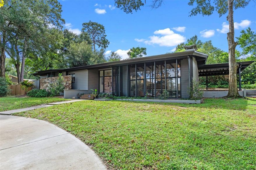 Fully remodeled mid-century modern home on a rare 0.64-acre corner homesite in Longwood’s desirable Sanlando Springs area with panoramic views of the pond and park across the street.

Situated across four original platted lots, this single-story concrete block residence offers 3 bedrooms, 2.5 baths, and 2,337 square feet of thoughtfully updated living space.

The living room features a dramatic 20’ x 12’ wall of windows overlooking the pond, fountain, and park, along with a striking floor-to-ceiling brick wood-burning fireplace that anchors the space. The designer kitchen is centered around a quartz waterfall island with seating and overlooks the patio and private garden. Clean modern lines define the space with concealed outlets, integrated controls, and a concealed dishwasher, while custom cabinetry includes full pull-out drawers for exceptional functionality and storage.

The primary suite features a spacious walk-in shower with rain fixtures. Bedrooms two and three share a Jack-and-Jill bathroom with a freestanding soaking tub. Two bedrooms include walk-in closets and French doors that open directly to the backyard.

Additional features include a skylit laundry area with built-in cabinetry, abundant storage throughout the home, and additional storage closets within the carport.

The fully fenced property offers expansive outdoor space including a vegetable garden and storage shed. A circular driveway in the front and a secondary private driveway behind the home provide flexible parking options.

No HOA. RV parking permitted with dedicated RV hookups. Additional upgrades include a whole-home water softener system and reverse osmosis filtration system.

Located across from the former Rolling Hills Country Club property and conveniently close to parks, shopping, dining, and major roadways, with quick access to Interstate 4.