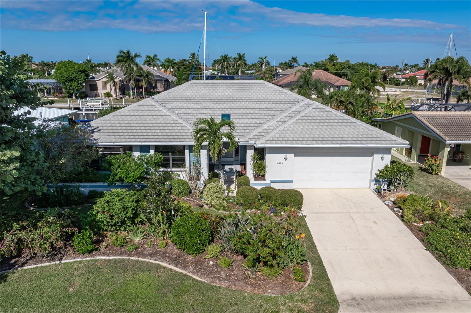 WATERFRONT HOME IN PGI W/**NEW TILE ROOF** & NEARLY INSTANT SAILBOAT ACCESS - Located in the original sailboat section of Punta Gorda Isles, this custom 3 bed/2.5 bath waterfront home delivers the ideal blend of boating convenience and Florida comfort. With 80 feet of seawall and a 30-foot concrete dock featuring water and electric hook-ups, boaters will appreciate the quick, deep-water access to Charlotte Harbor in five minutes or less. Inside, more than 2,400 square feet of living space showcases a bright, open floor plan with soaring ceilings and generous natural light. The main living area offers multiple entertaining zones, including a large great room, formal dining area, and custom wet bar. The adjoining family/media room provides the perfect spot for movie nights or quiet reading surrounded by your favorite books. The kitchen features sleek white cabinetry, Thermador stainless steel appliances (including convection oven/conv. microwave & induction range), granite counters, and a central island. A cozy breakfast area overlooks the pool and canal & features a built-in recipe desk. Tile floors run through the main living spaces, while the primary and one guest bedroom offer soft carpet underfoot. Master suite opens directly to the pool and lanai, offering a canal view, large walk-in closet, and updated bath with dual sinks and a walk-in shower. The split-bedroom layout ensures privacy for guests, with spacious rooms and an updated guest bath. Outdoor living is at the heart of this home. The lanai boasts an in-ground, heated lap pool with attached spa. A covered seating area and large sun deck surround the pool. An outdoor shower and pool storage closet complete the lanai. Keep your boat docked in your backyard at your private, 30ft concrete dock w/two SlideMoors. Set off on a grand adventure or simply take the boat out and grab lunch at a nearby waterfront restaurant! Other amenities include whole-house hurricane protection with a mix of Lexan and accordion shutters and an attached 2.5-car garage. Property is located on a quiet street yet is close to Fishermen’s Village, St. Andrews South Golf Club, and historic downtown Punta Gorda. While there's no HOA, the Punta Gorda Isles Civic Association (PGICA) offers access to a wide range of social clubs, boating groups, and community activities. The only requirement to joining is ownership or residency in Punta Gorda Isles. Experience the best of Florida’s boating lifestyle—quick harbor access, sunset views, and year-round waterfront living. Schedule your showing today.