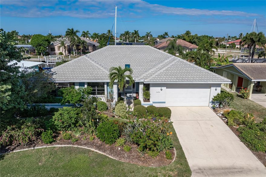 WATERFRONT HOME IN PGI W/**NEW TILE ROOF** & NEARLY INSTANT SAILBOAT ACCESS - Located in the original sailboat section of Punta Gorda Isles, this custom 3 bed/2.5 bath waterfront home delivers the ideal blend of boating convenience and Florida comfort. With 80 feet of seawall and a 30-foot concrete dock featuring water and electric hook-ups, boaters will appreciate the quick, deep-water access to Charlotte Harbor in five minutes or less. Inside, more than 2,400 square feet of living space showcases a bright, open floor plan with soaring ceilings and generous natural light. The main living area offers multiple entertaining zones, including a large great room, formal dining area, and custom wet bar. The adjoining family/media room provides the perfect spot for movie nights or quiet reading surrounded by your favorite books. The kitchen features sleek white cabinetry, Thermador stainless steel appliances (including convection oven/conv. microwave & induction range), granite counters, and a central island. A cozy breakfast area overlooks the pool and canal & features a built-in recipe desk. Tile floors run through the main living spaces, while the primary and one guest bedroom offer soft carpet underfoot. Master suite opens directly to the pool and lanai, offering a canal view, large walk-in closet, and updated bath with dual sinks and a walk-in shower. The split-bedroom layout ensures privacy for guests, with spacious rooms and an updated guest bath. Outdoor living is at the heart of this home. The lanai boasts an in-ground, heated lap pool with attached spa. A covered seating area and large sun deck surround the pool. An outdoor shower and pool storage closet complete the lanai. Keep your boat docked in your backyard at your private, 30ft concrete dock w/two SlideMoors. Set off on a grand adventure or simply take the boat out and grab lunch at a nearby waterfront restaurant! Other amenities include whole-house hurricane protection with a mix of Lexan and accordion shutters and an attached 2.5-car garage. Property is located on a quiet street yet is close to Fishermen’s Village, St. Andrews South Golf Club, and historic downtown Punta Gorda. While there's no HOA, the Punta Gorda Isles Civic Association (PGICA) offers access to a wide range of social clubs, boating groups, and community activities. The only requirement to joining is ownership or residency in Punta Gorda Isles. Experience the best of Florida’s boating lifestyle—quick harbor access, sunset views, and year-round waterfront living. Schedule your showing today.