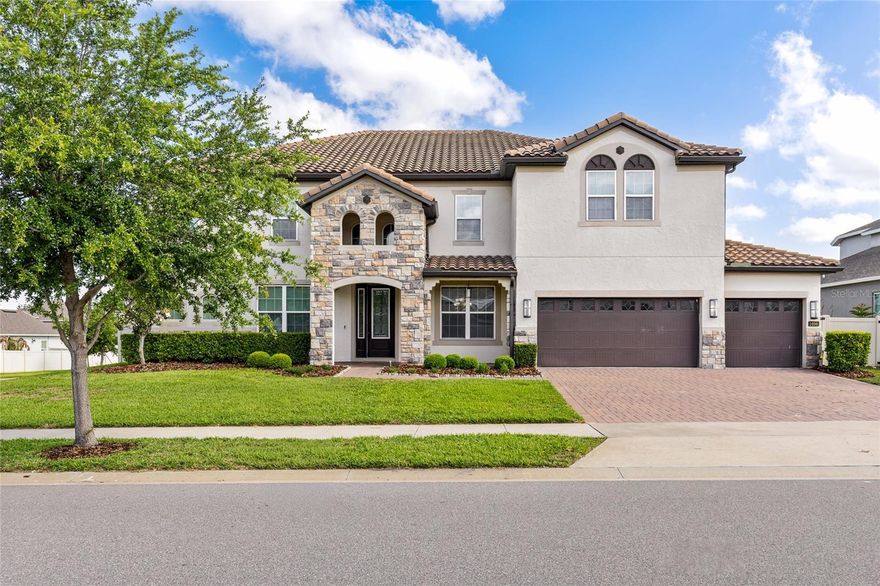 Experience refined Florida living in this stunning energy-efficient estate, perfectly positioned on an expansive corner lot in the highly sought-after Winter Garden area. Just minutes from Historic Downtown Winter Garden and within close proximity to Orlando’s world-renowned theme parks, this exceptional residence offers the ideal blend of elegance, comfort, and convenience.
This impressive two-story home features 7 spacious bedrooms and 4 beautifully appointed bathrooms, thoughtfully designed to accommodate multi-generational living. A luxurious owner’s suite and guest bedroom on the main floor provide flexibility and privacy, while five additional bedrooms are situated upstairs on either side of a generous game room and private home theater, creating the ultimate setting for entertainment and relaxation.
At the heart of the home lies a chef-inspired gourmet kitchen, complete with a breakfast bar, and café dining area, all seamlessly flowing into the expansive family room and overlooking the covered lanai. Elegant upgraded tile plank flooring enhances the main living areas, while plush carpeting adds comfort to the bedrooms and bonus spaces. Formal living and dining rooms, provide both sophistication and functionality.
Step outside to your private backyard oasis, where a gorgeous in-ground swimming pool, summer kitchen, and oversized covered lanai create the perfect environment for year-round entertaining. The fully fenced yard ensures privacy and ample space for outdoor enjoyment.
Car enthusiasts and active families will appreciate the three-car tandem garage with an additional single-car bay, ideal for extra parking, storage, or a golf cart. Modern smart home technology enhances convenience and security, while the home’s energy-efficient construction promotes a healthier, quieter lifestyle and significant savings on utility costs.
Residents also enjoy access to exceptional community amenities, including a dock on Lake Apopka, scenic parks, and walking trails, all contributing to the vibrant and active Winter Garden lifestyle.