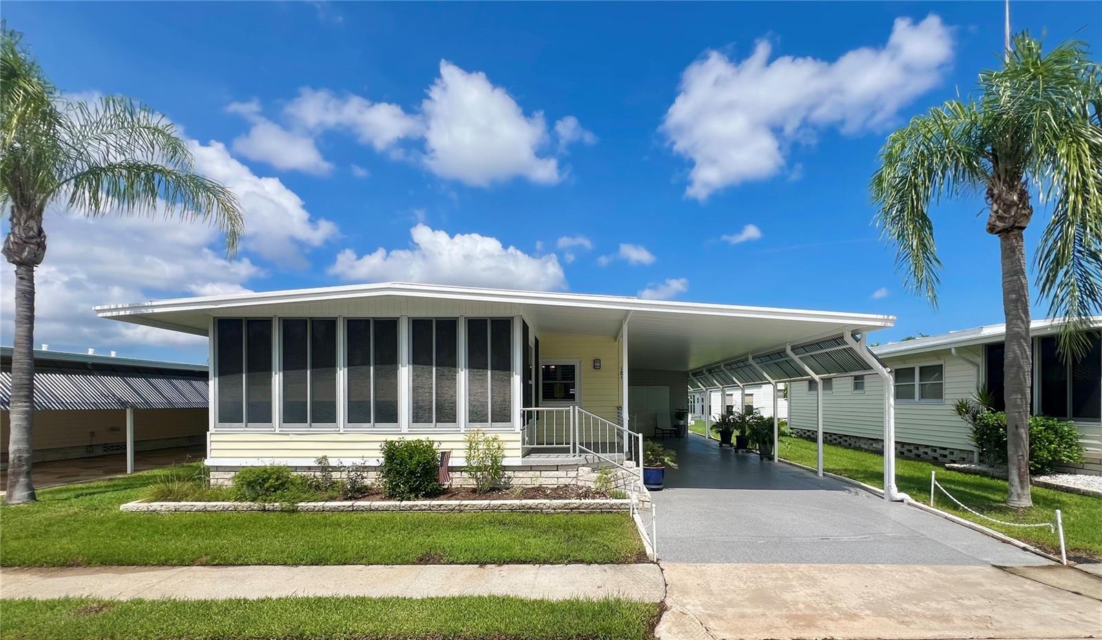 This beautifully renovated 2-bedroom, 2-bath home in the PET SECTION of the sought-after 55+ community of Fairway Village has been thoughtfully updated from top to bottom between 2021 and 2025. From the moment you arrive, pride of ownership is evident with meticulous maintenance and numerous improvements, including FEMA-recommended "House Hardening" completed in 2024, where most exterior screws were replaced, gutter mounts were reinforced, and all trim and windows were freshly sealed caulked and painted. Exterior upgrades between 2021 and 2023 include a newer roof over, vinyl siding, updated windows, vented decorative block skirting, decocrete driveway, front porch, rear steps, and an expanded rear concrete patio behind the extended shed. Under the home, a new vapor barrier, updated floor vents, and a NEW HVAC system were installed in 2022, while the carport was insulated in 2021 and new French drains were added in 2024. A full irrigation system was installed in 2021 with a digital timer added in 2023. The shed was also expanded and fitted with a new water heater in 2022. Inside, the home opens to a practical laundry/mudroom equipped with cabinets and a washer and dryer, ideal for keeping the living space clean. The updated kitchen boasts custom cabinetry with soft-close doors and some pull-out shelves, a large deep sink, modern lighting, and newer stainless steel appliances, all flowing seamlessly into the open-concept living room with abundant natural light and white plantation shutters on newer windows. Most of the furniture stays with the home, and a detailed list of exclusions is available. The front Florida room features ceramic tile flooring, easy-to-open and/or remove tinted windows, and custom-powered Hunter Douglas shades for year-round use. Throughout the rest of the home, luxury vinyl plank flooring with brand-new plywood subfloors was installed in April 2021. Both bedrooms are spacious, and the primary suite includes a walk-in closet. Each bathroom has been upgraded with modern faucets and fogless, light-up mirrors for a stylish and functional touch. Located in the heart of Fairway Village, residents enjoy access to a private 9-hole, par-3 golf course, a scenic 5-acre catch-and-release lake, two swimming pools, hot tubs, eight covered shuffleboard courts, and a brand-new 19,000+ sq. ft. clubhouse opened in 2022. This facility includes a 700-seat auditorium and ballroom, commercial kitchen, performance stage, fitness center, library, card and billiard rooms, multiple conference areas, cozy seating nooks, and free Wi-Fi throughout. The community’s active social calendar offers over 50 planned events per year. The affordable 2025 monthly maintenance fee of $401 includes water, sewer, lawn care, pest control, curbside trash pickup, high-speed internet, and over 220 Spectrum TV channels. Optional golf memberships are available for $440/year + tax for unlimited play, with modest resident green fees for non-members. With modern updates, community amenities, and affordable living, this turnkey home is a rare find—schedule your private showing today and make this beautiful house your home!