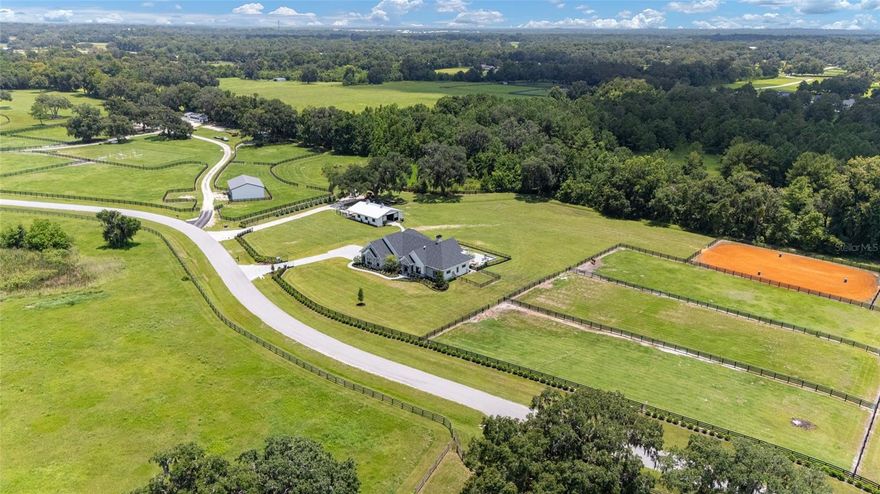 PRIVATE/OWNER FINANCING Options available for qualified purchasers. Just minutes from the World Equestrian Center and Golden Ocala Golf & Equestrian Club, this extraordinary 2023-built estate presents a rare convergence of modern architectural elegance and world-class equestrian functionality, all set across nearly 11 impeccably manicured acres behind private gates. Designed for the discerning equestrian, the property features a professional 105' x 150' riding arena with premium clay footing, four spacious barn stalls, an air-conditioned tack room, and dual wash racks, all thoughtfully positioned for efficiency, comfort, and horse welfare. Fully fenced and irrigated pastures and paddocks with water throughout provide an ideal environment for training, turnout, and long-term care, while two gated entrances ensure privacy, security, and seamless access for trailers and service vehicles.

The residence itself is a striking expression of refined contemporary design, featuring three bedrooms, three baths, and a private executive office with a temperature-controlled wine room. Soaring ceiling heights, from 12 feet in the main living spaces to nearly 19 feet in the great room, create an atmosphere of light, volume, and architectural drama. Kolbe crank windows, custom window treatments, and sleek tile flooring throughout reflect a polished yet relaxed aesthetic tailored to the equestrian lifestyle.

At the heart of the home, the chef’s kitchen is both functional and beautiful, appointed with quartz countertops, custom cabinetry, an Elica designer hood, Café gas range with pot filler, an oversized pantry, and a dedicated mudroom designed for life both in and out of the saddle. The great room is anchored by a dramatic gas fireplace and enhanced by a fully integrated Sonos surround-sound system with zoned audio extending throughout the home and outdoor living spaces.

The primary suite is a serene private retreat, featuring elegant chandelier lighting, dual oversized walk-in closets, and a spa-inspired bath with a temperature-controlled shower designed for true relaxation after a day at the barn or the showgrounds. Technically, the estate is as advanced as it is beautiful, featuring a whole-home generator with a buried 1,000-gallon propane tank, 400-amp electrical service, fiber-optic internet infrastructure, dual high-efficiency HVAC systems with Icynene insulation, and a three-car garage designed to accommodate larger vehicles and trailers with a European-style door system.

Outdoor living is nothing short of resort-caliber. A screened lanai with electric Phantom screens creates a cool, breezy environment that opens to a heated and chilled pool, summer kitchen, and fire pit, ideal for elegant entertaining or quiet evenings overlooking the grounds. The entire property is fully irrigated with precision Fibernom drip systems for lush landscaping year-round, and an advanced multi-camera security system covers both the residence and barn for complete peace of mind.

Every detail of this estate has been thoughtfully curated to deliver a rare combination of privacy, performance, luxury, and proximity, creating a truly turnkey equestrian lifestyle just moments from Ocala’s most sought-after destinations.