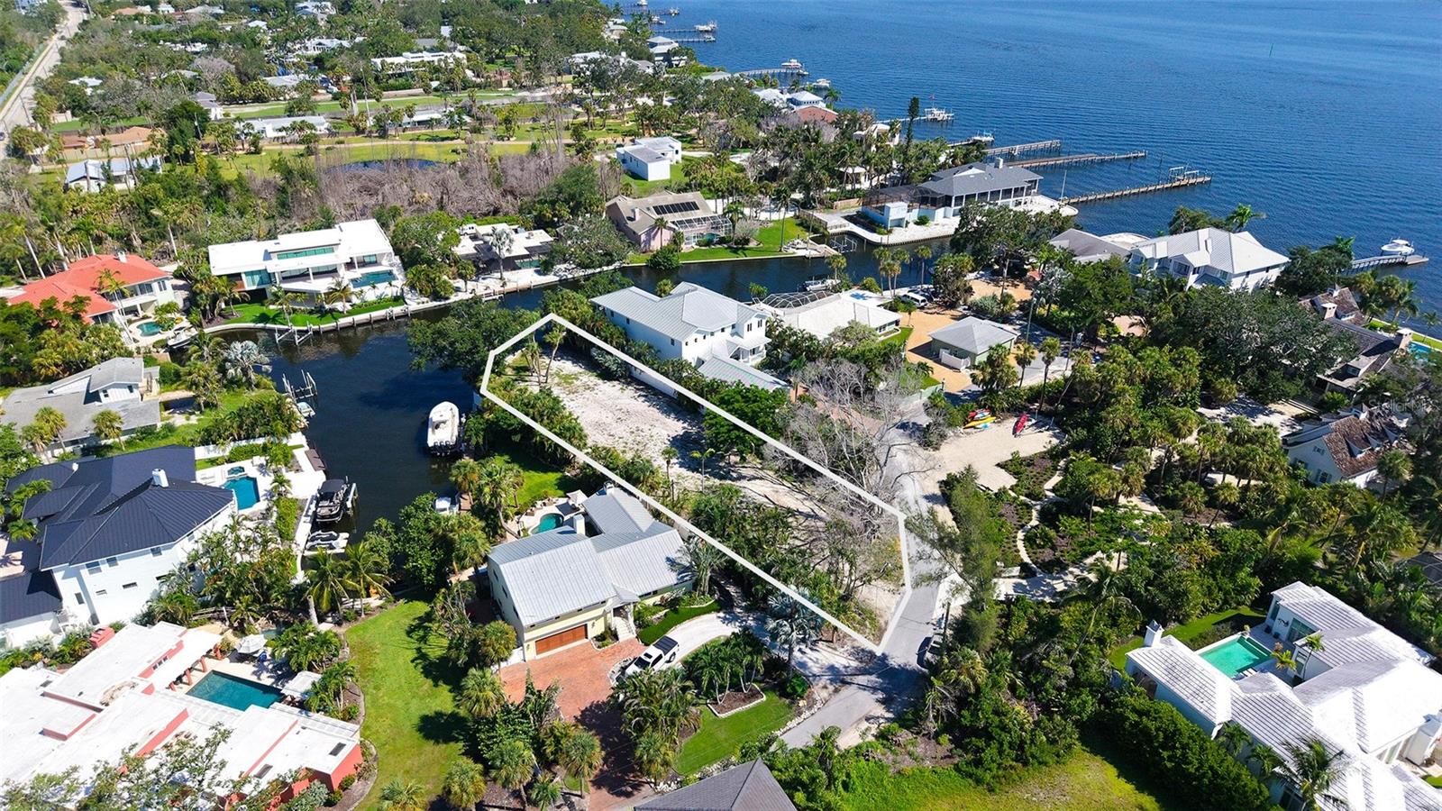 WATERFRONT – SIESTA KEY – BUILDABLE LOT *** Unlock the potential of nearly half an acre of PRIME waterfront property on one of Southwest Florida’s most desirable ISLAND destinations. This oversized, cleared, and ready-to-build lot offers the ideal canvas to bring your dream coastal retreat to life with unlimited design possibilities and no HOA restrictions. *** Tucked away just three homes from the deep waters of Sarasota Bay, this exceptional property positioned along a wide, picturesque canal, offers rare privacy without sacrificing convenience. With immediate access to boating, sailing, fishing, kayaking, paddleboarding, and more, whether you’re an avid angler, a weekend sailor, or simply someone who enjoys being near the water, this property provides endless possibilities for relaxation and recreation. *** Boating enthusiasts will appreciate the existing boat lift and deep-water, sailboat-accessible canal location with no fixed bridges—allowing smooth passage to the Intracoastal Waterway and beyond. Imagine enjoying the luxurious tropical breezes, watching stunning sunsets from your backyard, or launching your boat for a spontaneous day on the water - all without leaving home. From land, you will enjoy quick access to the #1 Siesta Key Beach, the South Bridge, restaurants, grocery stores, nightlife, and local favorites like cozy coffee shops and boutiques—all just minutes away. *** With its generous size and prime waterfront location, this remarkable lot offers the rare combination of space, tranquility, and proximity to open water. It’s the perfect setting for a luxurious custom home, a peaceful weekend retreat, or an investment in one of Florida’s most desirable waterfront communities. *** Don't miss this exceptional chance to create your own private paradise. Whether you’re building now or planning for the future, this property is a rare opportunity not to be overlooked.