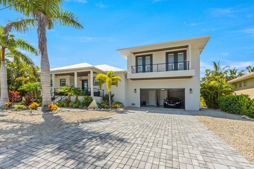 This new construction is a dream come true for boaters and water lovers! A stunning Key West style WATERFRONT canal home spans over 2,263 Sq. Ft. and offers a total of 3754 sq. ft. of pure luxury. Offered turnkey furnished and totally moved in ready! Completed in 2023, this home features an abundance of natural light, soaring ceilings, custom 4 inch plantation shutters and electric blinds for the sliders, HURRICANE impact windows and doors, and metal roof. The kitchen is a chef's delight featuring top-of-the-line stainless steel appliances including wolf, quartz countertops, soft close cabinets, 2 sinks, open shelving, separate wine fridge, and a generously large entertaining island. The living and dining areas seamlessly lead out to the outdoor covered patio, perfect for indoor/outdoor entertaining. The split floor plan offers maximum privacy, with the master en-suite featuring his and her closets, a separate soak-in tub and a huge walk-in rain shower, and double sinks. All bathrooms have unique and stylish modern tile finishes. There are three additional bedrooms, one with its own private en-suite bathroom and the other two sharing a jack and Jill bathroom. Enjoy the oversized epoxy 3-car garage for all your cars, golf carts and beach toys! In addition, the beautifully paved driveway offers ample parking for all your guests. Step outside to your backyard oasis where you'll find a heated salt pool controlled by wifi, spa and sun shelf, surround sound, an outdoor shower, and a huge composite dock for fishing and a 10,000 lb. boat lift. With direct access to Anna Maria Sound and the Gulf of Mexico and no bridges you can hop on your boat and be on the water in no time. The tropical landscaping is breathtaking with lighting and easy to maintain with shell and low maintenance plants. Located in the heart of Holmes Beach, you are close to all the boutiques and restaurants and only five minutes from the gorgeous Anna Maria beaches, this home truly offers the best of Anna Maria island living. Come and make this your very own waterfront paradise and experience all that Anna Maria Island has to offer! This stunning home is an absolute must-see.