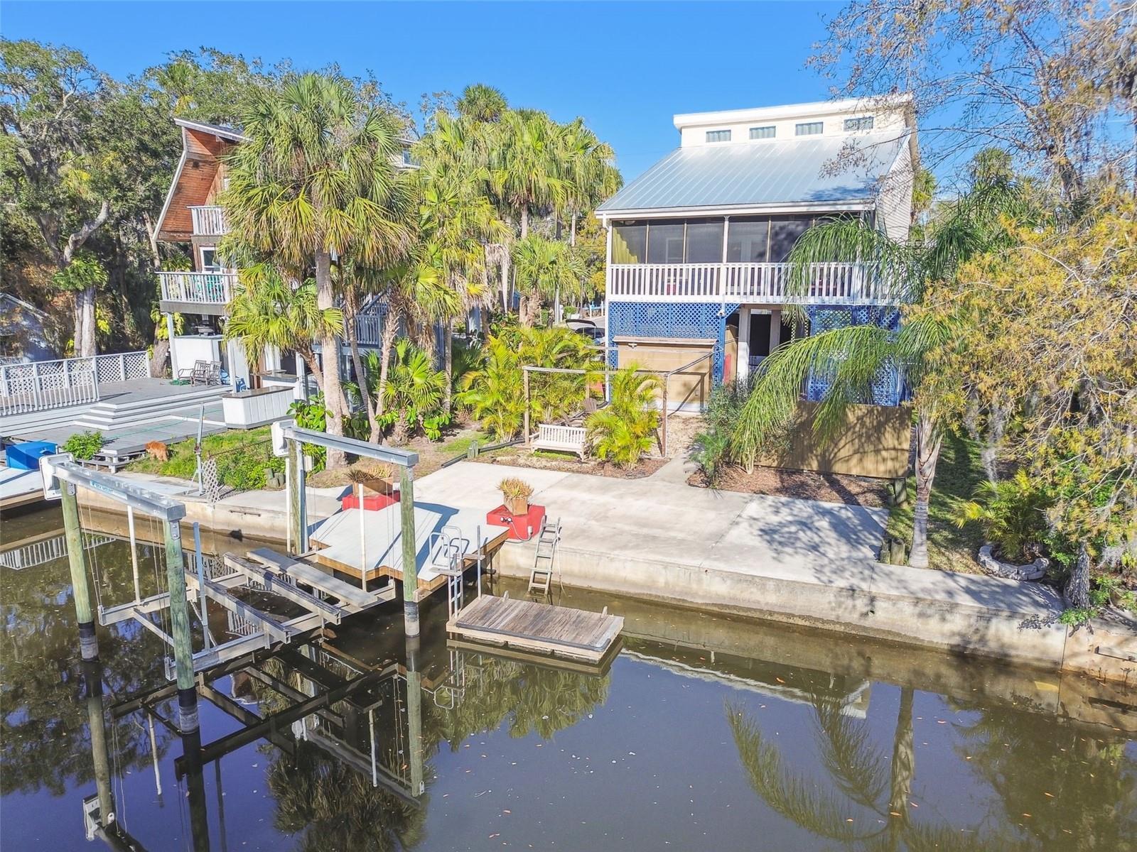 Stilt home on a canal with direct Gulf access. NO Storm or Wind damage offering unmatched peace of mind. Bring your RV, camper, boat, or golf cart—there’s plenty of room to park under the home. Head upstairs and enter through the front door or the spacious screened-in porch, featuring a No-See-Ums screen and stunning water views. Inside, soaring vaulted ceilings and an open floor plan make this home perfect for entertaining. The main level includes a large living and dining area that flows into an industrial-style kitchen with a generous pantry. A convenient laundry closet is just off the kitchen, leading to a renovated full bathroom. There's also a main-level bedroom with direct access to the bath. Upstairs, the master loft offers a spacious walk-in closet, a beautifully renovated full bath with a tub, and a private screened-in balcony. Natural light pours in through the loft windows, stretching the length of the house. The lush, mature landscaping adds to the tropical feel of the property. The backyard is designed for relaxation, with a seating area, fire pit, kayak/paddleboard rack, and an outdoor shower. Key features include a metal roof (2020), impact-rated windows (2020), HVAC/Heat (2019), vinyl flooring (2019), carpet (2021), and a remote-controlled 10K boat lift (2020) with composite decking. Parking is plentiful with a gate clearance of 9'10" wide and 11' high, providing space for a boat, large truck, or camper. There's also an additional boat/trailer pad (16’x10’) behind a locked gate, a shed for storage, and easy access to incredible boating and kayaking spots. Boat to your favorite restaurants and bars in Miller’s Bayou, cruise down the Cottee River, or take a day trip to Anclote Key. Brasher Park is just down the street, that you can walk or bike to. You’re just a short walk to Walmart, Dunkin Donuts, Culver's, and local hot spots, and conveniently located only 45 minutes to Tampa International. Downtown City of New Port Richey in 5 minutes. BOAT available for sale 2015 Sportsmans Heritage, less than 850 hours on the engine. Don’t miss out on this rare waterfront paradise—call today for your private showing!