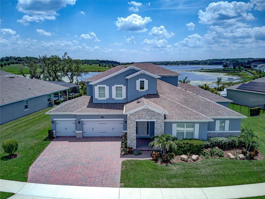 GORGEOUS LAKEFRONT POOL HOME BEING OFFERED IN THE TRANQUIL LAKE COMMUNITY, SANCTUARY AT TWIN WATERS! The home sits on a HALF-ACRE LOT on LAKE AVALON! This 5-bedroom, 4 and 1/2 bath, 4 car garage home has 4,258 heated square feet and 5,916 total square feet. The plan is perfect for MULTIGENERATIONAL LIVING with a guest (in-law) bedroom and ensuite bathroom downstairs; and upstairs the back bedroom has its own ensuite full bathroom. The GOURMET KITCHEN will delight the most avid chef with generous upgraded light gray shaker cabinets including modern hardware and stacked pot drawers for all those cooking gadgets! Sparkling white quartz countertops, meet high-end stainless-steel appliances including a 5-burner gas cooktop, double oven, microwave,  refrigerator, and dishwasher. Need lots of organized space in your pantry? No problem-this pantry comes with a professional organizer system including pullouts. You will love gathering around the large coordinating island complete with contrasting navy shaker cabinets, white quartz countertops, stainless farmhouse sink, and counter bar area! The rest of the downstairs living areas (great room, breakfast room, and formal dining room) flow open from the kitchen offering spectacular views of the lake. A pool half bath rests behind the kitchen for easy guest access. You will absolutely love the dedicated and professionally organized laundry room with sink, cabinets, and plenty of folding/hanging areas. Did I mention that the WHOLE HOUSE HAS PLANTATION SHUTTERS and EVERY CLOSET HAS “CALIFORNIA” PROFESSIONAL ORGANIZERS!!! The downstairs living area is covered with light gray, easy to maintain wood looking tile, and soft carpet around the great room TV area. The expansive downstairs primary suite features an extended flex room perfect for an office area, sitting room, or workout area. BOTH primary suite ROOMS LOOK OUT OVER THE salt chlorinated and screened POOL with SPA. Step right out your French doors into the heated spa as you watch the sun set over the lake! You will absolutely love the light, airy primary bathroom complete with free standing soaker tub, huge shower with frameless glass enclosure, and gorgeous white marble-looking porcelain tile covering the floor and shower walls. Light gray cabinets meet medium gray quartz countertops creating a true work of art! Look at the huge, organized closet perfect for all your clothes and accessories! All the bedrooms have a plush carpet for comfort. The upstairs features the bedroom with ensuite bathroom, two other bedrooms that share a bathroom, and a huge bonus room just perfect for game night, movie night, or just chilling as you look out at the lake! The new owner can build a dock on Lake Avalon. Enjoy the pool amenity and Lake Park area just inside the main entrance to the community. Sanctuary at Twin Waters is a convenient location just out from the hustle and bustle, but convenient to all that Winter Garden has to offer including Disney, the charming Downtown Winter Garden with the 20 mile West Orange trail network, Winter Garden Village with its shops and restaurants, and so many other fantastic activities which make this one of the top Central Florida areas to live in. Great local public schools as well as private schools surround the area adding to a great quality of life.