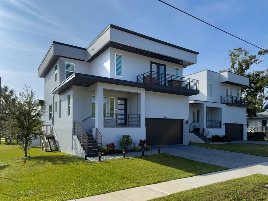 Discover modern living in this beautifully designed contemporary masterpiece—offered at an exceptional value in South Tampa. Step inside to soaring style with sleek 24x24 porcelain tile flooring that spans the entire first floor, creating a seamless and polished flow. You’re greeted by a bright formal living room up front, ideal for a reading lounge, home office, or sitting area.

The heart of the home is the open-concept kitchen, featuring 42" shaker cabinetry, quartz countertops, a generous center island with bar seating, stainless steel appliances, and plenty of space for a dining table. This functional and stylish layout opens to the main living area and extends outdoors to the spacious deck overlooking the fully fenced backyard—perfect for weekend barbecues, pets, and entertaining. With its large corner lot, there’s ample room to add a pool.

Built on an elevated stem wall, the home offers enhanced protection and peace of mind during heavy Florida rains. Upstairs, thoughtful design continues with a striking custom accent wall and modern chandelier in the staircase, plus additional accent walls that elevate the style of several bedrooms.

All of this is tucked within a charming South Tampa neighborhood, just minutes from Gandy Boulevard, Bayshore Boulevard, MacDill AFB, Westshore Marina District, and top shopping and dining options. A rare opportunity to enjoy modern finishes, clean lines, and contemporary flair in a highly desirable location—move-in ready and truly a must-see!