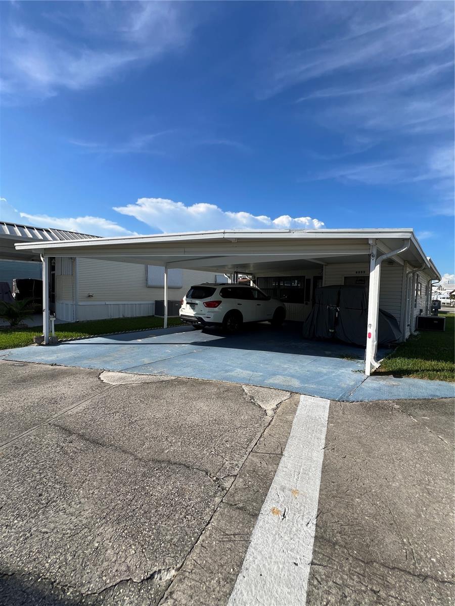 Ancient Oaks~ 55+ Community. Large corner lot with RV wrapped (enclosed) with huge Florida room under air. 1 bed 1 bath- furnished with a double carport. 2 outside utility rooms(workshop) washer & dryer is located in the rear one, large patio outback. This is a real cutie and ready for your winter home- priced to sell!