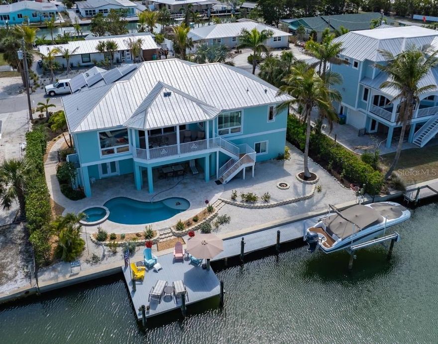 Own your Slice of Paradise!  Are you a boater? Beachgoer? Sun Worshiper?  This meticulously designed elevated custom home is just 3 blocks from the beautiful beaches of Anna Maria Island and was built to FEMA exacting standards (allowing for the best wind and flood insurance rates).  It is move-in ready incurring no damage from the recent hurricanes.  With 90 feet of frontage on Watsons Bayou (one of the widest and deepest canals on Anna Maria), boaters have direct access to Anna Maria Sound and the ICW with no bridges to maneuver.

This single-owner home offers an open concept great room with 3 bedrooms (2 ensuite) and 3 bathrooms.  The heart of the home is the expansive kitchen which boasts a large island – perfect for meal preparation, casual dining and entertaining friends and family.  The kitchen is outfitted with an abundance of cabinetry, granite counters, stainless steel appliances, bar sink, ice machine and a beautiful wine cooler.  The adjacent dining and family room areas form an exceptional great room with 14’ vaulted ceiling.  Large sliding glass doors lead out to the upper covered deck offering an additional dining area with incredible views of Watsons Bayou and the ICW.  

The primary suite features an oversized bedroom with views to the Bayou and a luxurious bathroom with a rain shower.  The guest suite features dual vanities and a private outdoor balcony with an abundance of sunshine.  A third bedroom and bathroom along with a large laundry room complete the living level.  Downstairs, step outside to the private backyard oasis where you’ll find a custom heated saltwater pool with a large sun shelf for lounging or relaxing.  The pool is complete with an integrated waterfall spa and an adjacent outdoor shower room offering both hot and cold water and a changing area.  The spacious covered lanai offers plenty of entertaining space for relaxing and dining.  Additional outdoor amenities include a large sun dock, 10,000 pound boat lift and a fire pit.

Inside on the ground level is an oversized 3-car garage with an air conditioned storage room – plenty of room for all of your pool, boat and beach toys. Contributing to lower utility bills are solar panels on the roof, foam insulation in the attic and hurricane-impact Low-E windows and doors.  Schedule an appointment and this property can be your Slice of Paradise!