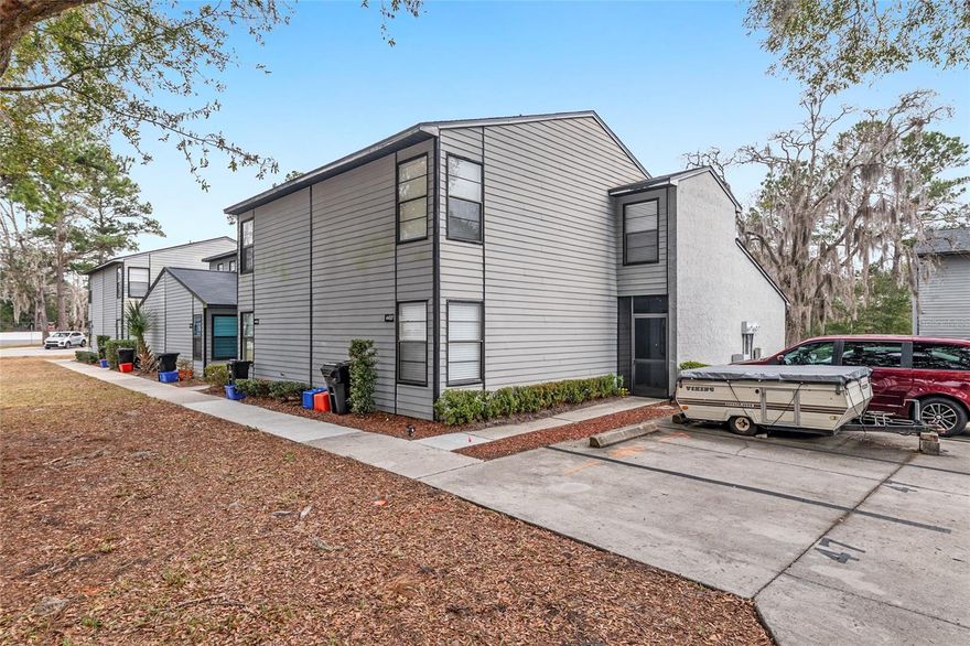 In the heart of Marchwood, just minutes from Gainesville’s shops and dining and with easy access to the city’s vibrant core, this true end-unit condominium presents a refined and tranquil living experience. Light-filled interiors unfold in a crisp, neutral palette, complemented by flooring in cool tones that evoke a sense of calm and understated elegance. Thoughtful improvements enhance both style and function, including new light fixtures, updated door hardware, and stylish window treatments throughout, along with a brand new hot water heater (2025), newer roof (2024), and newer AC (2024) for added peace of mind. A graceful entryway leads to an expansive living space where natural light pours through oversized windows, while a sculptural modern ceiling fan adds a clean architectural accent and enhances airflow. The adjacent kitchen features enduring white cabinetry, polished quartz countertops, stainless steel appliances, and a thoughtfully integrated passthrough that maintains connection to the living and dining areas without compromising spatial definition. The dining area opens to verdant surroundings through full-length glass doors, offering a gentle connection to the outdoors. A full bedroom and bathroom on the main level provide ideal flexibility for guests, multigenerational living, or everyday convenience, while two additional spacious suites upstairs offer the rare luxury of choosing your primary bedroom location to suit your lifestyle. Framed by lush landscaping and moments from Gainesville’s shops, restaurants, and medical centers, this move-in ready residence is beautifully prepared and simply waiting for you to call it home.