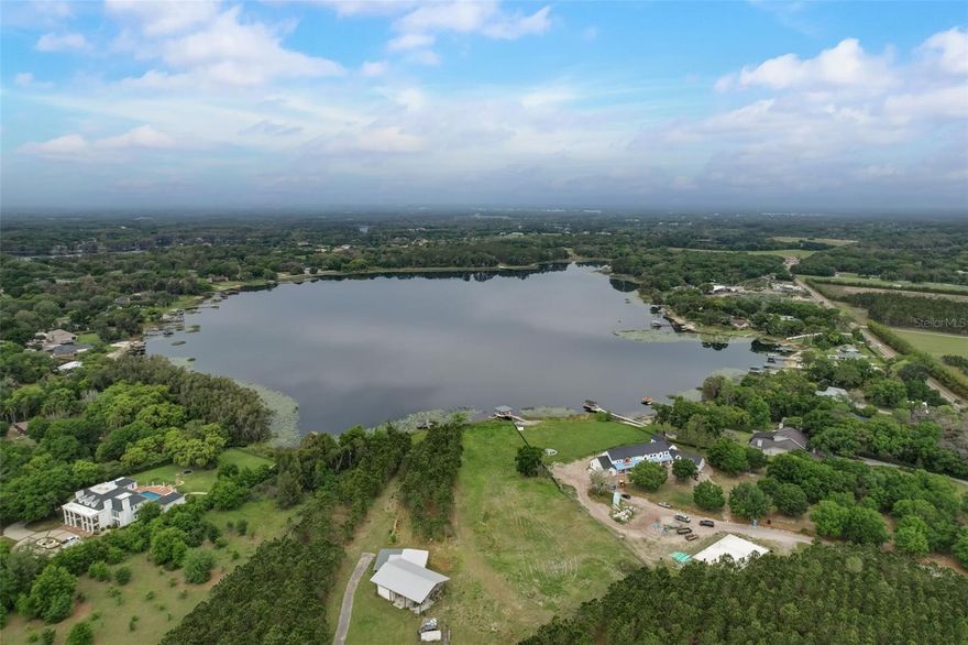 Speak to listing agent #2 before visiting the property. This exceptional waterfront property boasts over five acres of pristine land, primed for creating your private oasis. Indulge in the tranquility of a sprawling estate sitting waterfront on the idyllic Lake Calm with ample room for a long-gated driveway, a grand residence and a sparkling pool. Enjoy the exhilaration of motor boating and water skiing from your backyard. Lake Calm offers a haven for water sports enthusiasts. The cleared section adjacent to the frontage offers a prime canvas for your dream home, ensuring a clear view of the lake. Mature trees bordering the property near Gunn Highway provide a sense of privacy and a natural backdrop. If even more land is preferred, adjacent Lot 1 is also available for purchase, allowing you to create a more expansive estate. This property is free of restrictions often associated with HOAs, providing you with the freedom to design and build your dream home exactly as you envision it.