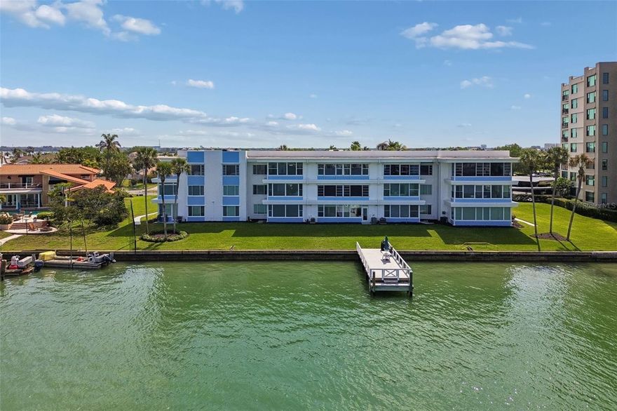 Welcome to Island Estates, where waterfront living meets effortless coastal style in the heart of Clearwater Beach. From the moment you arrive, you’ll appreciate the beautifully maintained community, ample parking, and convenient access via elevator or stairs to this second floor residence. This fully updated 2 bedroom, 2 bathroom condo offers unobstructed panoramic views of Mandalay Bay and a light, airy interior designed to complement its stunning surroundings. Stepping inside, you’re welcomed by an open and inviting floorplan filled with natural light and a seamless flow throughout. The upgraded kitchen serves as the centerpiece of the home, featuring granite countertops, a large center island with seating, stainless steel appliances, a wine refrigerator, and custom cabinetry, all thoughtfully designed for both everyday living and entertaining. The kitchen opens effortlessly to the spacious living and dining areas, where custom built-ins, modern paneled doors, and recessed lighting elevate the space while maximizing both function and style. The enclosed lanai adds valuable additional living space and showcases breathtaking water views, creating the perfect setting for morning coffee or evening relaxation. The primary suite offers a peaceful retreat with serene water views, generous closet space, and an updated ensuite bathroom with high-end finishes. A well-appointed secondary bedroom and updated guest bathroom provide comfort and privacy for family or visitors. A full-size washer and dryer are conveniently located within the unit. Recent updates include hurricane and UV protected windows, AC system, water heater, electrical, water softener, and more, offering peace of mind for years to come. The building is well maintained and has successfully passed the required Milestone inspection with no assessments. Step outside to enjoy the community dock, complete with water and electric, ideal for fishing, kayaking, boating, or simply unwinding while taking in the sunset. Residents also enjoy access to a grill and smoker, perfect for waterfront gatherings. Surrounded by a mix of private homes and waterfront residences, this community offers a welcoming and relaxed atmosphere. Located just minutes from Clearwater Beach, Island Way Grill, Publix, local dining, shopping, and downtown Clearwater entertainment, this prime location offers both convenience and lifestyle. Enjoy walking or biking through the neighborhood, or hop on the Jolly Trolley for easy access to the Clearwater Marine Aquarium and nearby attractions. This is your opportunity to own a beautifully updated waterfront condo in one of Clearwater Beach’s most desirable communities.