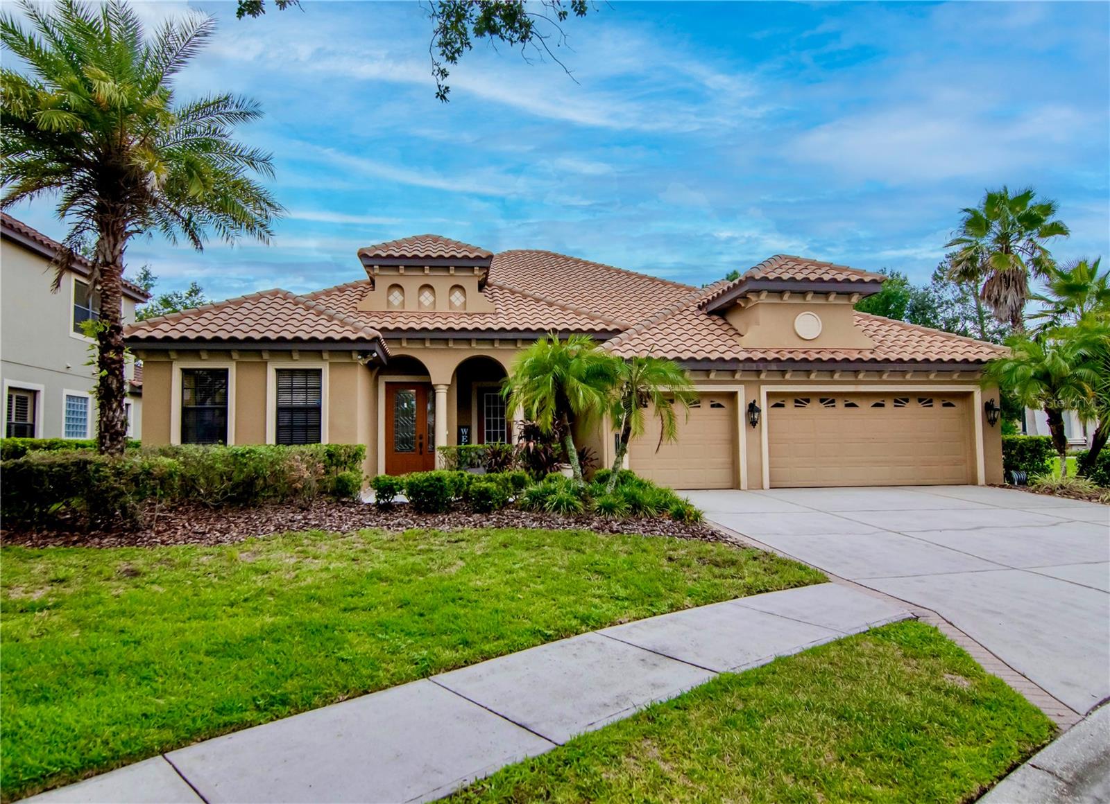 Welcome to this beautiful home in the highly sought-after gated community of Grand Hampton! Enjoy resort-style living in this 24-hour guard-gated neighborhood, known for its beautiful setting and exceptional amenities. This beautifully maintained residence is ideally situated on a quiet cul-de-sac with tranquil conservation views in the backyard. Boasting 5 bedrooms, 3.5 bathrooms, and 3,445 square feet of well-designed living space, this home offers a fantastic floor plan that lives like a one-story. Four bedrooms, including the owner’s suite, are conveniently located on the main floor, while the fifth bedroom and a spacious bonus room are upstairs. Step inside to discover gorgeous new flooring that flows seamlessly throughout the main living areas. The formal living and dining rooms provide an elegant space to entertain, complete with sliding glass doors that open to a screened-in patio, ideal for indoor-outdoor living. The kitchen features a cozy eat-in area and opens to the family room, which showcases a custom stacked-stone accent wall—a perfect spot to relax and unwind. The owner’s suite includes a versatile adjoining bedroom, ideal for a nursery, home office, or private sitting area. Two additional main-floor bedrooms provides flexibility, with one currently set up as a playroom. The second floor features a spacious bonus room complete with a wet bar, walk-in storage, private balcony, bedroom, and full bathroom—ideal for use as an in-law suite or for multigenerational living. You will love the fully fenced backyard where there is plenty of space to add a pool. Located in the desirable Grand Hampton community, residents enjoy resort-style amenities including 24-hour gated security, a state-of-the-art clubhouse, fitness center, multiple playgrounds, a heated resort-style pool with a lagoon water slide, lap pool, heated spa, and both tennis and basketball courts. Grand Hampton also offers convenient access to I-75 and I-275, AdventHealth Hospital, PHCC, AdventHealth Center Ice, The Shops at Wiregrass, Tampa Premium Outlets, a variety of dining options, and much more.