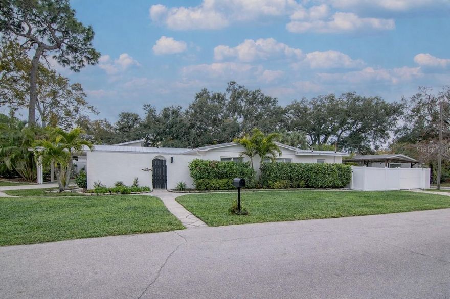 Come see this charming Florida home set on a well-sized corner lot in the heart of South Tampa and steps away from A-rated schools. Before entering the home, you are greeted by a private courtyard which could be used for outdoor dining, or an extra play area for children. The home's bright kitchen opens up to a generously sized living room and dining area. All new LVP flooring was installed throughout the home, including the three bedrooms. The bathrooms were recently renovated and updated. The large backyard has been beautifully maintained with a patio great for outdoor entertaining and a covered workspace ready for projects or golf cart parking. The utility room holds the washer and dryer and lots of extra storage. The property offers three separate driveways and a covered carport. The carport also provides an excellent opportunity for future expansion of the primary bedroom and bathroom. Major improvements include a metal roof installed in 2023 and all new ductwork in 2025. No flooding! This house is ready for its new owners!