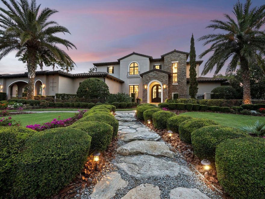 Welcome to a truly distinctive residence, masterfully envisioned by acclaimed architect Francis Rodriguez and expertly built by Nutter Construction. Located in the exclusive, gated enclave of The Lake Club in Lakewood Ranch, this remarkable home offers a secure and serene lifestyle, ideal for those seeking refuge from hurricane threats. Spanning nearly 5,000 square feet of air-conditioned space, the home features 4 spacious bedrooms, 3.5 luxurious bathrooms, and 4 climate-controlled garage bays (one with a lift for two vehicles), all set on a pristine half-acre lot at the end of a quiet cul-de-sac. Privacy and quality craftsmanship define every inch of this exceptional estate. From the moment you arrive, the home’s elegance is unmistakable. A stone-accented porte-cochère and stately cast iron double doors set a sophisticated tone. Inside, imported limestone flooring from Alicante, Spain, and soaring 12-foot ceilings with wood-beamed accents create a warm yet refined atmosphere. Every element—from impact-rated windows, doors, and sliders to the premium Viking appliances in the chef’s kitchen—has been thoughtfully selected to offer the highest level of luxury and resilience. The primary suite, situated on the main floor, offers a serene retreat with a spa-like bath featuring a soaking tub, walk-in shower, and expansive closets. Step through to your private patio—a peaceful spot to enjoy a coffee, meditate, or watch the sun dip below the horizon. Upstairs, a second terrace reveals stunning views of the manicured landscaping and tranquil lake beyond. Outdoors, the west-facing patio—with electric screens to keep open for unobstructed views and closed when needed—boasts an elegant pool, spa, and waterfall. Entertain with ease thanks to a fully outfitted outdoor kitchen, perfect for casual get-togethers or elegant evenings under the stars. Designed with flow and light in mind, the floor plan delivers seamless transitions between spaces, making everyday living effortless and enjoyable. As a resident of The Lake Club, you’ll have access to an unmatched array of amenities, including the Grande Clubhouse, dual swimming pools, game and billiards rooms, fitness and wellness facilities, tennis and pickleball courts, and a gourmet dining room with an on-site chef. With 24-hour guarded security, you’re free to explore the scenic walking trails, lush parks, and sparkling lakes in complete peace of mind. For those seeking a refined lifestyle in a fortress-quality home away from Florida’s coastal risks, this property is an extraordinary sanctuary of style, strength, and seclusion. Make this exceptional residence your safe haven.