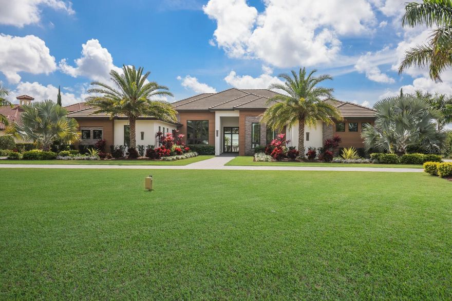 Designed with a nod to the modern movement of architectural styles and positioned on a scenic 1.71 acres in the exclusive and sought-after gated community of The Concession, this residence showcases clean lines, exceptionally planned indoor-outdoor spaces, and the latest in smart home technology. Voted “Best Overall Home” by Parade of Homes in 2021, the former Newcastle model was built by John Cannon encompassing 4,814 square feet of generously proportioned one-story living including private casita, and an expansive outdoor retreat encompassing 2,806 sqft screened lanai with extensive open and under cover spaces grounded with deep gray slate pavers, soaring accent ceilings, full summer kitchen, lounging chaise deck, putting green, fire pit, PebbleTec heated saltwater pool/spa with sun shelf, panoramic clearview screen, and a separate nature viewing deck to enjoy the lake views beyond. 10' accordion-styled impact glass walls with black iron horizontal lines seamlessly connect the resort-styled outdoor living space to a grand great room with sumptuous hardwood flooring, gas fireplace and stunning beam-accentuated ceilings. Dinner guests are treated to an open feel surrounded by disappearing cornerless glass doors and an all-glass temperature-controlled wine room with backlit agate accent wall.  Meanwhile chefs will delight in the oversized kitchen with show-stopper sized windows, two separate marble islands, Albrecht wood cabinetry, a hidden pantry with built-in cabinetry, and all high-performance appliances. An impressive club room directly off lanai beckons for entertaining complete with built-in beverage center, luxuriant ceiling design and direct access to an open courtyard. Relax and unwind in the owner’s quarters positioned on a private wing, offering a spectacular ceiling treatment, large scale windows overlooking the lake, direct lanai access, two oversized walk-in customized closets, and a luxuriously appointed bath with two separate vanity station wings anchored by an oversized all-glass dual entry shower at its center, a jetted tub surrounded by walls of glass looking into a private courtyard with outdoor shower, and even two separate water closets. The private casita off the lanai is optimal for guests with its own morning bar, walk-in closet, private full bath, volume beamed ceiling and stunning views. On a separate wing of the home there are two additional guest suites generous in size, both with walk-in closets and connected to private full baths.  The residence also offers an impressive office behind double-entry doors with elevated step up area, built-in shelving and accent sconce lighting.  Other notable highlights of this 7,704 total square foot residence includes a brilliantly located laundry room with cabinetry, sink, and desk area, Navien tankless water heater, built-in mudroom area, a dual split side load 4-garage, one with an air-conditioned wall unit, and Control4 home automation and networking system unifying lighting, audio, video, climate control, and security. This bespoke offering defines modern refinement beckoning a lifestyle fulfilled in this renowned community infamous as the home to the World Golf Championship PGA golf tournament in February 2021, to the World Champions Cup in December 2023, and to its striking oak hammocks, pines and large lakes, all near dining, shopping, polo, events in the vibrant Lakewood Ranch and UTC area, yet still nearby to the enriching culture and beaches of Sarasota