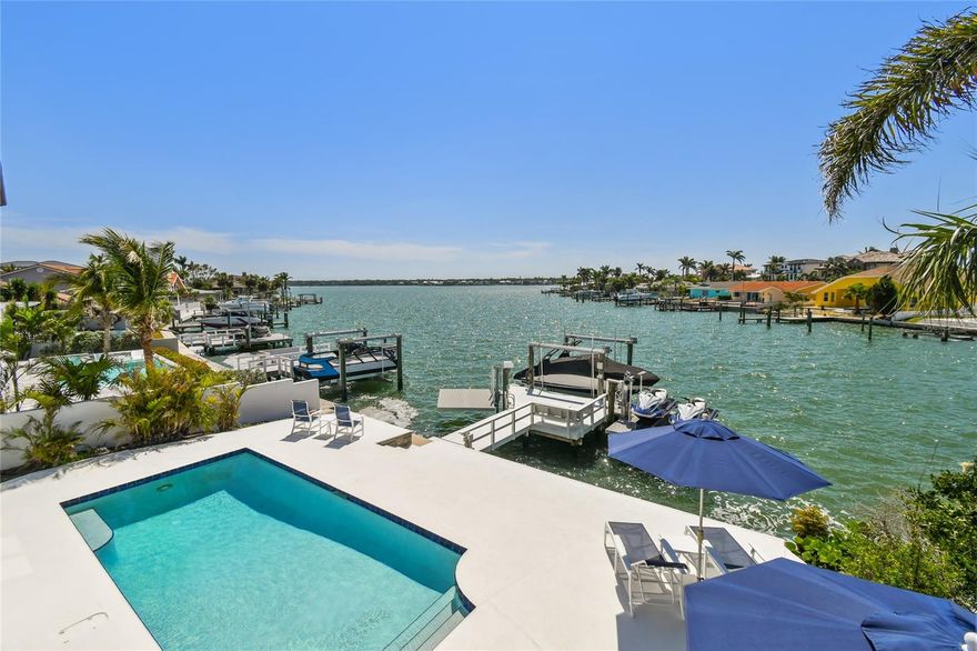 Welcome to the pinnacle of coastal luxury in the prestigious enclave of Belleair Beach where everyday living feels like a world-class waterfront vacation. This spectacular five-bedroom, five-bath estate delivers 3,793 sq. ft. of refined elegance, magnificent architecture and unforgettable views stretching across the shimmering Intracoastal waterway.
Step through the grand entry and feel the home unfold with breathtaking impact showcasing soaring ceilings, gleaming marble floors, and walls of glass framing mesmerizing water vistas from sunrise to sunset. The gourmet kitchen is a chef’s fantasy displaying granite counters, premium stainless appliances, gas cooktop, two dishwashers, touchless faucet, Bosch refrigerator, and a full-size wine refrigerator ready for lavish entertaining.
Two versatile first-floor bedrooms include a dedicated office with built-ins and a private ensuite bedroom with a handicap-accessible bath. Upstairs, an alluring loft leads to two guest bedrooms and an extraordinary primary suite featuring dual closets, a jewelry closet, a spa-inspired bath with soaking tub, oversized shower, and dual vanities. There is a private bonus room off of the primary bath currently being used as a gym, with panoramic water views and its own balcony completing this luxurious sanctuary. Remote-controlled electric window treatments throughout the entire home elevate the ease of everyday living.
Step outside and indulge in your private paradise. A heated saltwater pool, standalone spa, expansive waterfront patio, and a fully equipped dock with a 10,000-lb boat lift, a jet ski lift (for 2 jet skis) and a kayak lift/launch, all with water and electricity. The home comes
equipped with a Generac generator servicing the entire home, adding priceless peace of mind. 
Belleair Beach’s private resident-only beachside is just a short distance or golf cart ride away, along with boutique dining, shopping, and vibrant beachside entertainment with nearby Indian Rocks Beach and Clearwater Beach. All watercrafts are available for purchase but DO NOT convey with the sale of the home. This spectacular WATERFRONT HOME experienced NO WATER INTRUSION OR STORM DAMAGE. FLOOD POLICY is ASSUMBLE and reasonably priced.