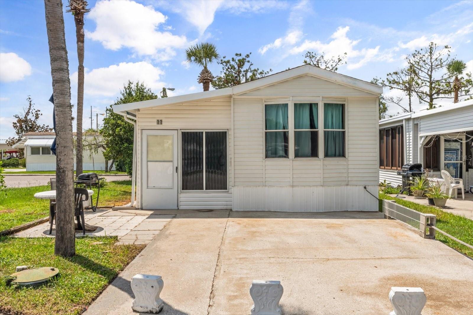 Charming manufactured home located on a desirable corner lot. This one-bedroom residence offers a flexible floor plan with potential to create a second bedroom or office space. The spacious living room features a large window that fills the home with natural light. Enjoy the benefits of a community that includes access to a community pool.