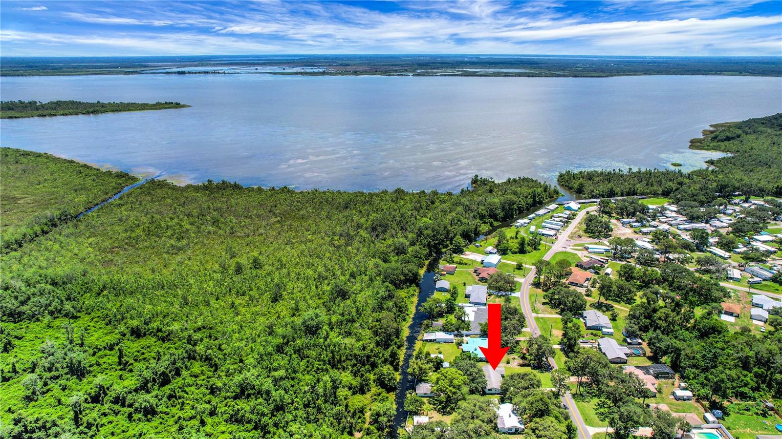 Welcome to your charming 2 bedroom 2 bathroom boathouse canal front home that leads to Lake Griffin, which is part of the chain of lakes. This spacious .43 acre lot has a private boathouse with boatlift that gives easy access to boating adventures plus extra storage besides the attached garage. Enjoy fishing from the sea wall area, where the fish are plentiful. The large backyard with picnic tables provides a great place to entertain while taking in the beautiful views. Inside, you can enjoy an abundance of natural light thanks to newer large double paned rear-facing windows that frame stunning lake views. This room gives extra entertaining space as the home also offers a living room. Most of the floors are tile, NO CARPET! The kitchen has a closet pantry and a window over the sink with lake views. The inside laundry room has plenty of cabinets for storage and a handy utility sink. For peace of mind the roof was replaced in 2018 and the HVAC in 2019. Located within 15 minutes of The Villages and even closer to shopping and restaurants, this home offers the perfect balance of peaceful canal front living with easy access to modern conveniences.