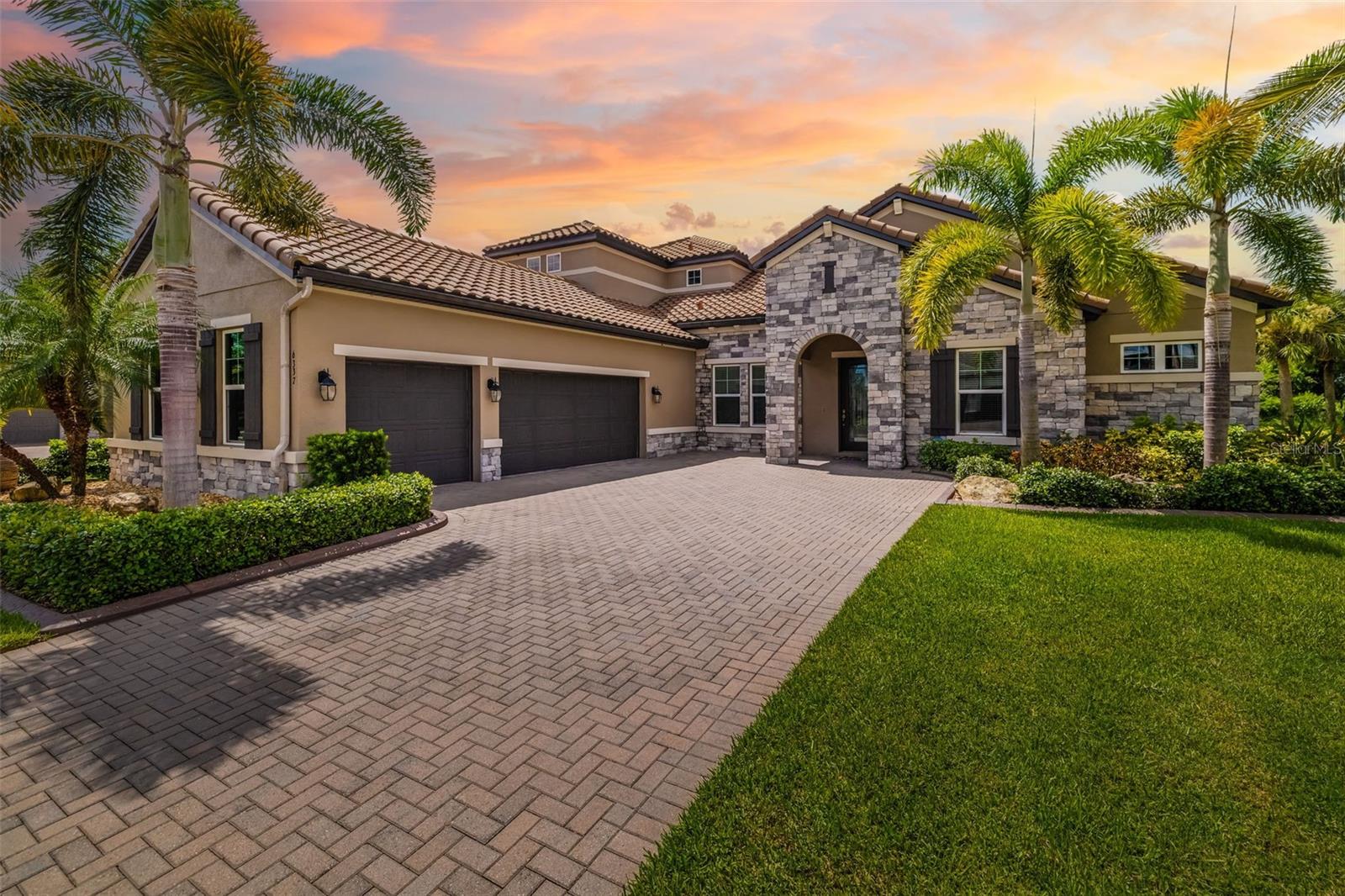 Nestled behind the gates of Rivo Lakes, this stunning home exudes timeless elegance with its impressive Tuscan-inspired facade and exquisite stone accents. FRESHLY PAINTED LIVING AREA, BEAUTIFUL LIGHT NEUTRAL COLOR. The meticulously landscaped grounds are adorned with lush tropical foliage, setting the stage for a truly exceptional living experience. Step inside to find a spacious, open floor plan with soaring ceilings and custom millwork throughout. Gorgeous custom Italian inlays grace the floors, adding sophistication to the space.
This home offers 4 spacious bedrooms, 4 luxurious bathrooms, a bonus room, den, formal dining room, and a game room—plenty of space for entertaining or family relaxation. The gourmet kitchen is a chef’s dream, featuring custom cabinetry, granite countertops, high-end stainless steel appliances, and a cozy café dining area. A massive granite center island with counter-height seating seamlessly connects to the expansive family room, creating an ideal flow for both casual and formal gatherings.
Upstairs, you'll find a private retreat with a large bonus room, bedroom, and bathroom, offering both comfort and versatility. The master suite is a true sanctuary, located on its own wing of the home, complete with a spa-like 5-piece en-suite and a generously sized walk-in closet. Sliding doors lead to the lanai, where you can relax and enjoy tranquil views of the serene pond.
Why wait for new construction when you can move right into this better-than-new, custom home today? Whether you're teeing off at a nearby golf course or enjoying cocktails with friends, this home is the perfect setting for every lifestyle. Priced to sell...welcome home!