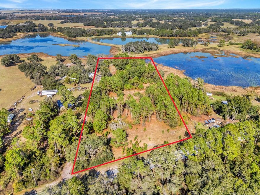 Welcome to a rare opportunity to own approximately five acres in Groveland, offering hard road frontage with a beautiful blend of open spaces, mature trees, and natural Florida landscape. Fully fenced and NO HOA, this property provides exceptional potential for building a custom home, creating a private estate, or establishing an agricultural or recreational retreat. 

The land features a mix of cleared areas and wooded sections, allowing flexibility for future improvements while preserving privacy and scenic surroundings. The elevated areas provide ideal home site possibilities, and the natural vegetation creates a peaceful buffer from neighboring properties. With wide road frontage and a gated entry, access is convenient for both residential and utility use.

The back portion of the property offers stunning views of the surrounding lakes and wetlands (approx 3/4 acre per Lake County), adding an attractive natural backdrop and enhancing the sense of seclusion. Whether you envision a homestead with space for animals, a workshop, or a tranquil residence surrounded by nature, this parcel delivers the space and versatility to bring those plans to life.

Located just a short drive to Groveland, Clermont, and major connecting highways, this property combines rural living with convenient access to shopping, dining, and daily essentials. Survey available. This unique acreage is ready for its next chapter, bring your vision and make it your own.