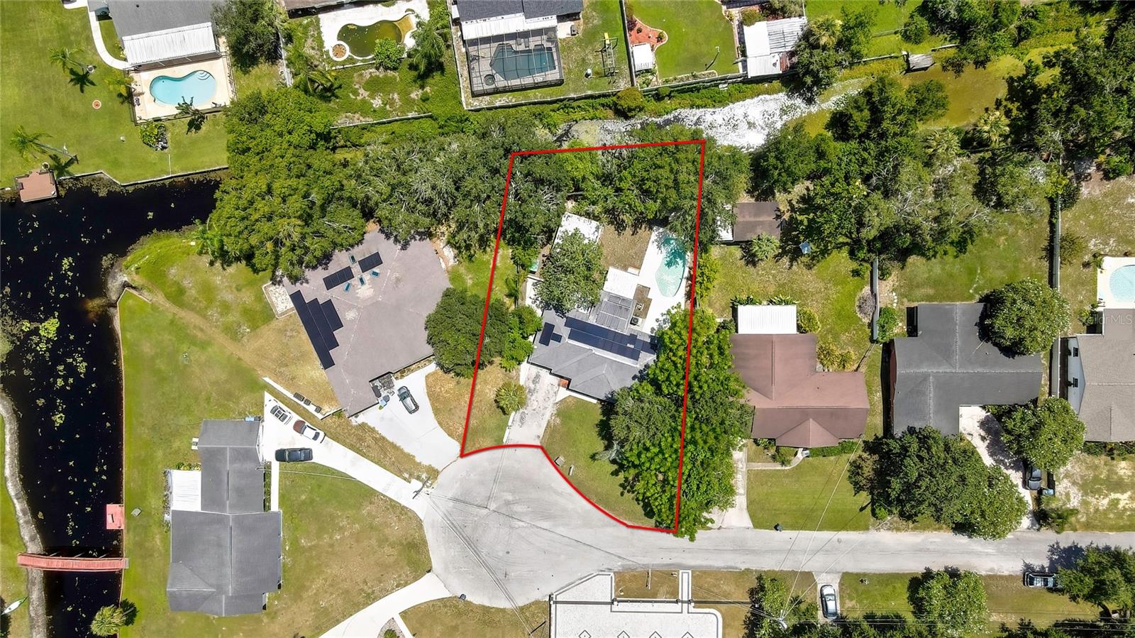***Solar panels & Roof (2019) will be paid off at closing—delivering energy savings to the new owner.*** Tucked away on a peaceful cul-de-sac in the desirable Tracer’s Lake Keen Estates, this charming 4-bedroom, 2-bath home offers 1,816 sq ft of well-designed living space. From the moment you arrive, the spacious driveway and inviting front porch create a warm first impression, setting the tone for the thoughtfully appointed interior. Step inside to discover an expansive, sunlit layout. Rich laminate wood flooring flows throughout the main living areas, complemented by elegant 18-inch tile in the kitchen. The open-concept floor plan allows for effortless movement between rooms, making it ideal for both everyday living and special occasions. At the heart of the home is a beautifully updated kitchen—a true chef’s dream—featuring gleaming granite countertops, a large central island with bar seating and prep space, a crisp subway tile backsplash, and raised panel cabinets. A full suite of stainless-steel appliances, including a range with a sleek vent hood, dishwasher, refrigerator, and a double stainless sink perfectly positioned beneath a wide picture window, completes this stunning culinary space. Just off the kitchen, the dining area is framed by oversized windows that flood the room with natural light, creating a cheerful setting for casual meals or elegant dinner parties. The spacious living room is designed for comfort and connection, offering a cozy place to relax, watch TV, or gather with loved ones. The private primary suite is a serene escape, with French glass doors opening directly to the pool deck and an ensuite bathroom featuring a soothing jacuzzi tub, a tiled shower combo, a granite vanity, and tasteful finishes throughout. A converted garage now serves as a versatile bonus bedroom, complete with its own A/C ducts—ideal for guests, a home office, or creative space. The interior laundry room includes a stacked washer and dryer, both of which convey, adding convenience to your daily routine. Toward the rear of the home, a bonus area offers additional cabinetry, granite counters, a prep sink, and a decorative backsplash—perfect for entertaining or transforming into a custom bar, coffee nook, or entertaining station. From here, step out to the beautifully stamped concrete pool deck and discover your private backyard retreat. The freeform pool invites you to unwind under the sun or host unforgettable weekend gatherings. The fully fenced backyard provides plenty of room for both relaxation and play, while the 18x18 metal detached shed provides generous space for tools, storage, or a workshop—making up for the absence of a house garage. A private well and water softener system offer added value and self-sufficiency for the property. A small canal at the rear of the property provides access to Lake Keen, an approximately 30-acre freshwater lake—adding a touch of natural charm without the burden of heavy maintenance. A/C, ducts and insulation 2019, Water Heater 2017, House plumbing 2019 & Pool pump 2023. Optional low fee for Lake Keen community park! With quick access to US-41, SR 54, and the Suncoast Parkway (SR 589), commuting to Tampa, the airport, and surrounding areas is effortless. Nearby Dale Mabry Highway offers a variety of shopping, dining, and entertainment options just minutes away—blending quiet neighborhood charm with everyday convenience.
