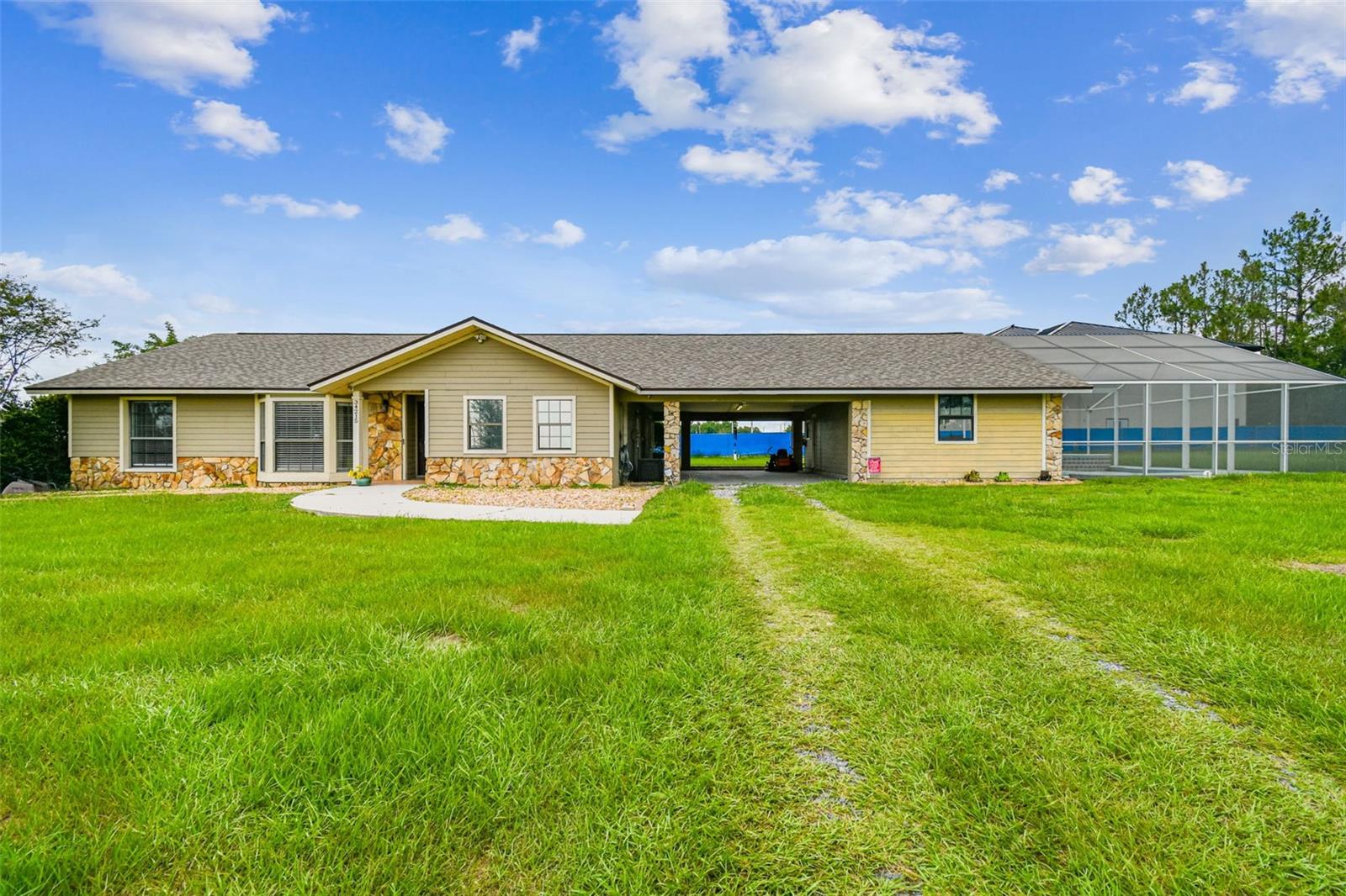 Welcome to your private slice of paradise! Nestled on 2.92 sprawling acres, this charming 3-bedroom, 2-bath home offers the perfect blend of peaceful country living with proximity to top schools, shopping, and amenities. Bring your toys, horses, or RV — there’s plenty of space for a barn, workshop, or guest parking, and absolutely no HOA or CDD restrictions to limit your vision. Step inside to discover a bright and airy layout, highlighted by soaring ceilings in the main living area and an open design ideal for entertaining. French doors lead to a versatile enclosed lanai — perfect for a home office, game room, or cozy reading nook.The split-bedroom floorplan ensures privacy, with a spacious owner’s retreat featuring its own bath, separated from the secondary bedrooms. Outdoors, enjoy your own private resort! Added in 2014 a screened, in-ground heated saltwater pool with a waterfall spa, along with an extended lanai and attached carport — perfect for hosting guests or relaxing in peace. A newer roof adds even more value and peace of mind, making this home move-in ready for years to come. Whether you're dreaming of a small homestead or simply a more relaxed lifestyle, this property has it all — wide-open acreage, endless possibilities, and a location that’s both peaceful and convenient. Additionally this property has seperate power and water hook up so come hook up your RV or add your own livestock to the property. Just minutes to historic Downtown Dade City, scenic parks, and an easy drive to Wesley Chapel's growing shopping and entertainment district.Rare opportunity to own land, freedom, and lifestyle — all in one place. Schedule your private showing today.
