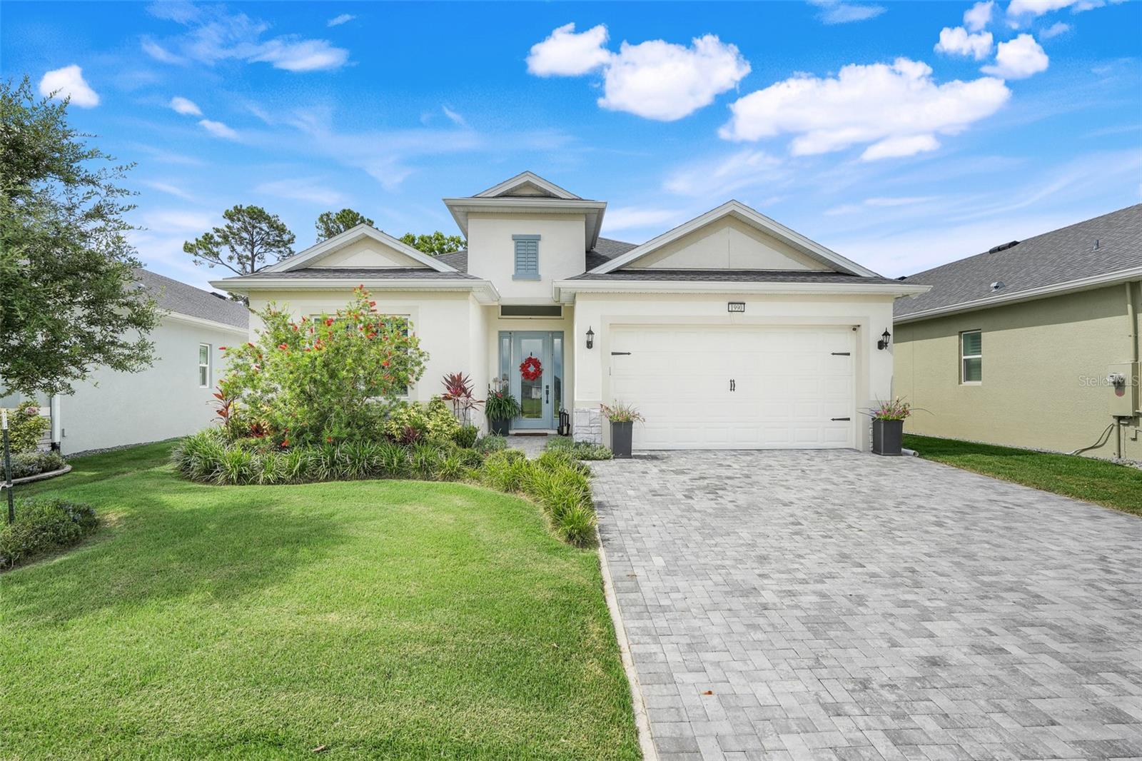 Step inside this stunning central Florida residence where elegance meets thoughtful upgrades at every turn. 1990 Wallingford Loop, built in 2023, is located in one of Central Florida's most desirable 55+ communities. Residents enjoy a gated community with exceptional amenities, luxurious active clubhouse, expansive pool, fitness center, miles of sidewalks, RV storage, private boat launch, fishing, croquet, bocce ball, basketball, tennis and pickleball courts.... This exceptional home boasts impact-resistant windows, a rare and valuable feature in this area offering both safety and peace of mind.
As you enter, you are greeted by the soaring 13 foot foyer ceiling creating a sense of spacious luxury. Beneath your feet, personalized porcelain tile flows throughout the home, masterfully designed to emulate the classic look of marble, offering both style and durability. At the heart of the home is a chef's dream kitchen featuring a large central island topped with gleaming high-end quartz countertops. A striking canopy hood rises above the upgraded 30-inch stainless steel gas cooktop blending functionality with a sleek design. Nearby, a dry bar with elegant glass-front cabinets adds both charm and convenience for entertaining. The Great Room has a tray ceiling with the refined beauty of crown molding creating a sense of luxury. No detail was overlooked--from upgraded interior doors that add a touch of modern sophistication, to the epoxy-coated garage floor, combining form and function in every corner. This home is a true showcase of quality, craftsmanship and design rarely found in most 55+ communities--ready to impress even the most discerning buyer.