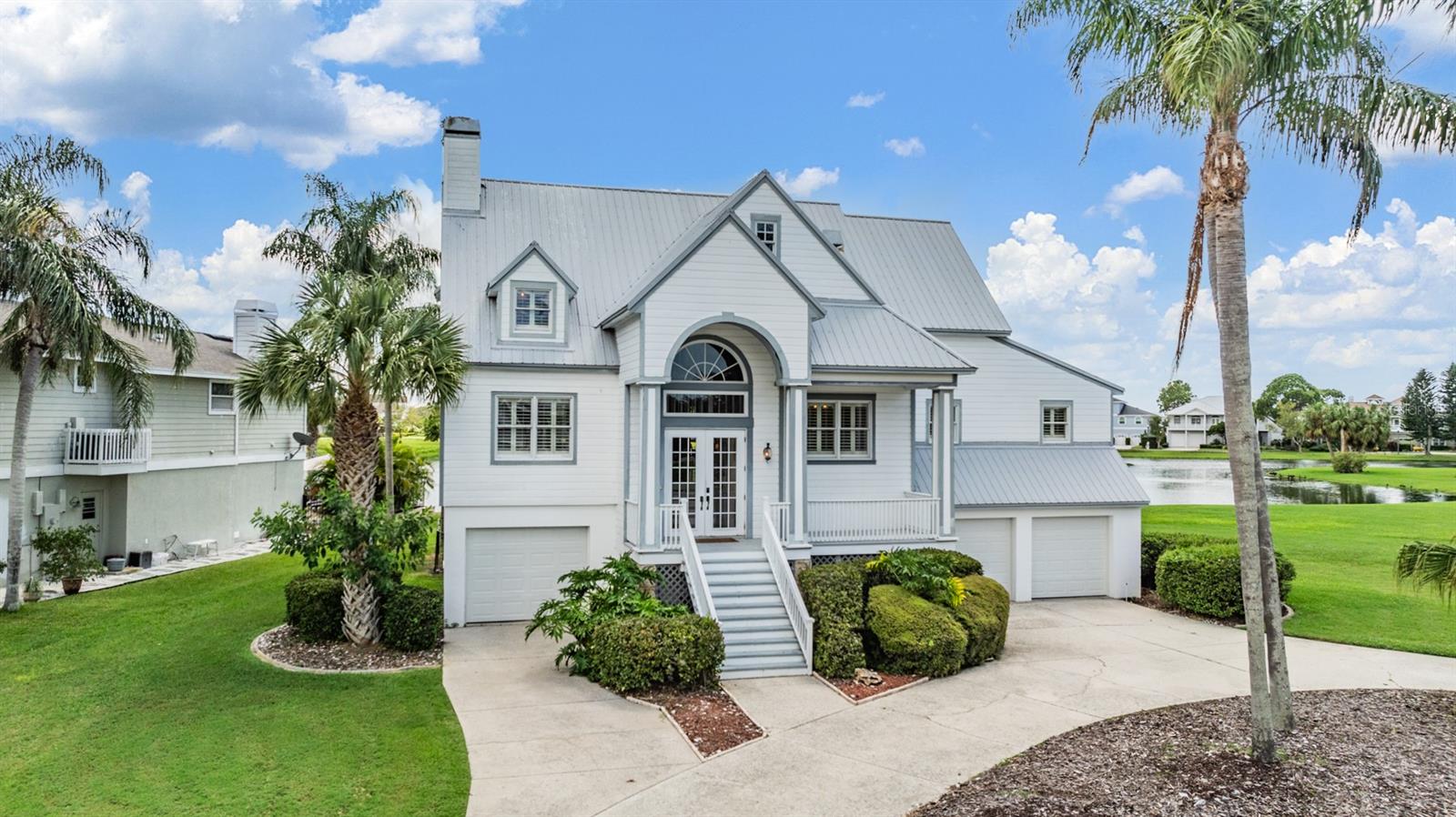 Experience coastal living like never before in this one-of-a-kind, custom-built 4-bedroom, 3-bath masterpiece, where every room offers stunning views of a serene lake and a vibrant bird sanctuary—a true haven for nature lovers. The gourmet kitchen, recently upgraded with high-end Kraftmaid shaker-style cabinets, new stainless steel appliances, a propane gas range, and elegant tile flooring, is a chef’s dream come true. The home’s open floor plan is designed to illuminate the space with natural light, accentuated by soaring volume ceilings and a double-sided fireplace. Sliding doors seamlessly blend indoor and outdoor living, leading to a spacious screened deck with panoramic water views that stretch from the tranquil lake to the expansive bay. Crafted with meticulous attention to detail, this residence boasts rare post-and-beam construction with updated siding, Andersen double-paned impact windows, a brand-new dual-zoned A/C system, and a 50-year stainless steel roof - marrying durability with architectural charm. Abundant storage options throughout ensure a clutter-free lifestyle, while the bonus room offers the perfect setting for a personal fitness center or a cozy guest retreat. The oversized 3-car garage is a car enthusiast’s dream, complete with a workshop area and ample space for a boat, jet-ski, or prized vehicle. Whether you’re soaking in the sunrise with a coffee in hand or unwinding at sunset on one of the two decks, every moment here is framed by nature’s beauty. Located in the exclusive, gated community of Harbour Watch, this home offers more than just a place to live—it’s a lifestyle. Enjoy peace of mind with 24/7 manned security, and take advantage of the community’s top-tier amenities, including lighted tennis courts, a junior Olympic-sized pool with a heated spa, a private clubhouse with an exercise room, a playground, a gulf-front gazebo, and a fishing pier. All this is just minutes from local beaches, shopping, restaurants, and the charming Tarpon Springs, where every day feels like a vacation. This home isn’t just move-in ready; it’s ready to redefine your idea of Florida coastal living.