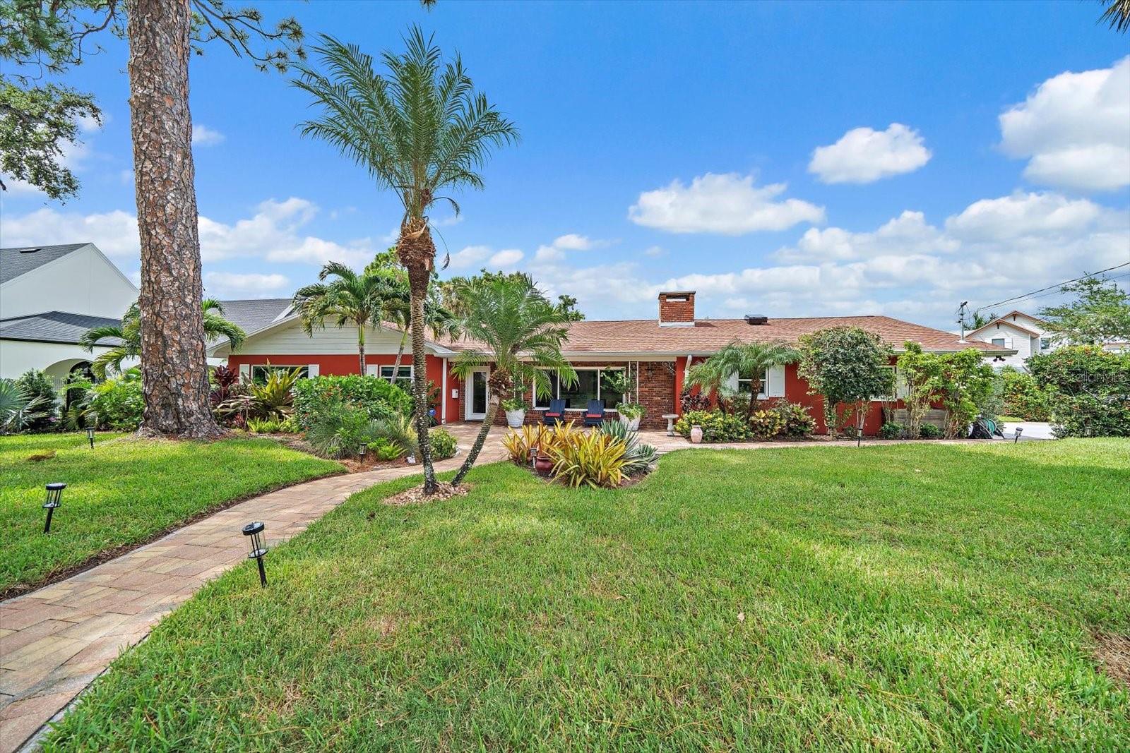 Move-in ready and perfectly positioned in the heart of beautiful Belleair, this stunning home offers refined Florida living just one block from the water and beautiful Winston Park, yet sits high and dry in a non-flood zone. Bursting with curb appeal, this meticulously maintained home features tropical native landscaping, a newly pavered front walkway and patio, and a welcoming entryway. Inside, a bright and open floor plan is enhanced by designer finishes, neutral luxury vinyl flooring, and a seamless flow between spacious living areas. The living room is filled with natural light, boasts electric blinds, and is anchored by a striking wood-burning fireplace, while the adjacent dining room connects effortlessly to the gorgeous white kitchen with stainless steel appliances, granite countertops, custom tile backsplash, wine fridge, and pass-through to the pool. The family room stuns with white paneled walls and soaring pine ceilings with exposed beams, creating an unforgettable atmosphere. Sliders open to a private, lush backyard oasis, where you will find expansive outdoor living that is a perfect blend of luxury and functionality, including 2 distinct covered areas, each offering a unique retreat, and a large shimmering pool with a 10 foot deep-end. Encasing the pool is a soaring screen enclosure providing protection from leaves and insects while maintaining an open, breezy atmosphere. The primary suite is a peaceful retreat with a walk-in custom closet, natural light, private glass door to the pool, and an ensuite featuring a furniture-inspired vanity and walk-in shower. Additional bedrooms are equally well appointed with custom closets, and built-ins. Extras include a 3-car garage with new custom flooring, impact windows and sliders, whole house generator, and electric blinds, Situated in one of Pinellas County’s most desirable neighborhoods, you're just minutes from two private golf clubs, boutique shopping, local dining, and the area's most beautiful beaches. Don’t wait—this Belleair beauty won’t last long!