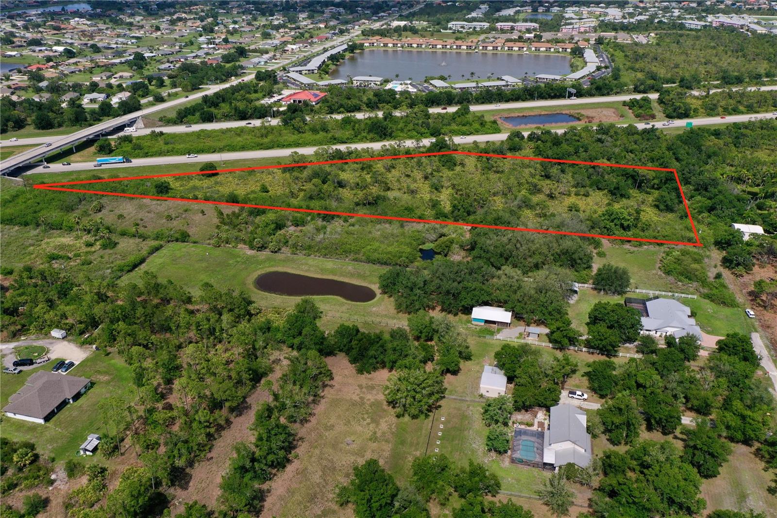 6.4 Acres of residentially zoned (RE1) Private Acreage property in the peaceful community of Suncoast Estates. Combine this with 5 ACRES FOR SALE adjacent to this property (Which has an existing pond on property) to have 11.4 ACRES TOTAL! Tucked near the end of a quiet street, this property has exceptional privacy at the end of the street, perfect for creating your own private retreat. With **no HOA fees or deed restrictions**, you have the freedom to design and build your custom dream home exactly the way you envision it. Conveniently located just off Kings Highway, you’re only minutes from major shopping centers, popular restaurants, and daily conveniences. Boaters will love being less than 10 minutes from Charlotte Harbor and the nearest boat ramp, while travelers enjoy quick access to both US-41 and I-75. The property lies outside the Scrub Jay mitigation area (per Charlotte County GIS) and is surrounded by new residential construction, making it an excellent investment for future growth. You're also just a short drive to the Sunseeker Resort, Downtown Punta Gorda, Port Charlotte Town Center, Charlotte Sports Park (home of the Tampa Bay Rays spring training), and numerous top-rated golf courses. Best of all, some of Southwest Florida’s most beautiful beaches are just 30 minutes away. Whether you're planning your forever home or looking for a smart addition to your real estate portfolio, this parcel has the potential to check all the boxes. Don’t miss this incredible opportunity—schedule your showing today!
