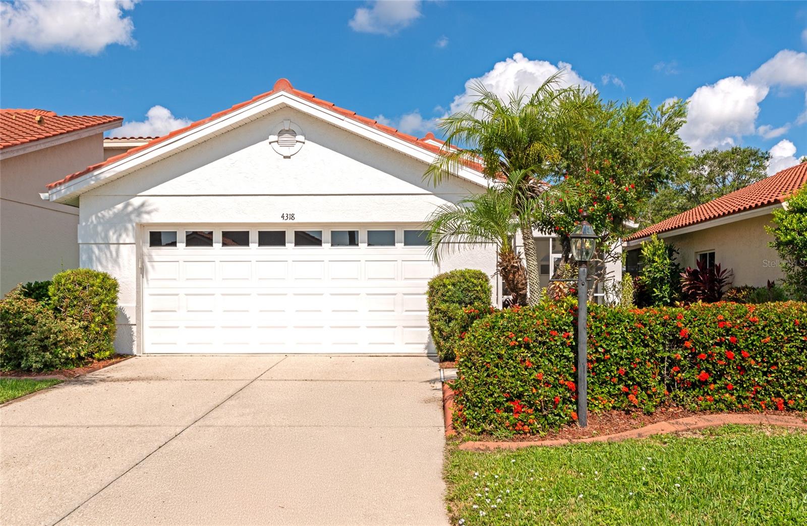 Nestled beneath swaying palm trees, this beautifully maintained 2 bedroom, 2 bathroom home is located in the highly sought-after community of Seville at Center Gate. From the moment you arrive, you’ll appreciate the manicured landscaping, spacious 2-car garage, and charming screened-in front patio—the ideal spot to sip your morning coffee while enjoying peaceful bird calls and the serene natural surroundings. Step inside to discover a light-filled, airy layout featuring soaring volume ceilings, soft neutral tones, and elegant Italian tile flooring throughout the entry, living area, hallway, and front bedroom—creating a timeless and cohesive aesthetic. The fully equipped kitchen is designed with the home chef in mind, boasting ample cabinetry, matching appliances, granite countertops, and a breakfast bar that overlooks the expansive living room—perfect for entertaining or casual everyday living. Just off the kitchen is a cozy dining area ideal for intimate meals or lively dinner parties. The oversized primary suite offers a true retreat with its own separate lanai access, a walk-in closet, garden tub, separate walk-in shower, and a tubular skylight that fills the space with soft natural light while also maximizing privacy. The second bedroom is generously sized and ideal for a guest room, home office, creative studio, or more. Step through the sliding glass doors into your own tropical escape—a spacious 20’ x 20’ screened lanai surrounded by lush landscaping for ultimate tranquility. Whether you're hosting weekend cookouts, enjoying your garden, or relaxing under the stars, this outdoor space is ready for true Florida living. The partially fenced backyard adds a layer of privacy and space for pets or peaceful gatherings. Seville at Center Gate is a quiet, well-established, low-maintenance community where HOA fees include lawn care and cable TV. Enjoy a convenient Sarasota location just minutes from I-75, Doctors Hospital, downtown, shopping, dining, top-rated schools, and the award-winning Gulf Coast beaches. This move-in-ready gem combines comfort, style, and convenience in one dreamy package. Don’t miss your chance—schedule your private showing today!