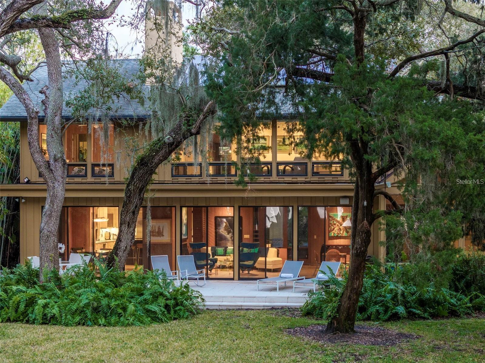 Stunning Mid Century Masterpiece, close to beach and walk to Southside Village. Featuring cypress inside and out. High ceilings and open spaces offer comfort and airiness, while the walls of glass sliders and windows fill the interior with natural lighting while showcasing gorgeous views of the lush landscaping. The expansive great room features floor-to-ceiling sliders and a wood-burning fireplace, creating a warm and inviting space, while the open kitchen with an island is perfect for creating culinary delights and entertaining. Also on the first level is an additional living space and a large flex room with sliders leading to a screened outdoor patio. This bonus room is ideal for a home gym, playroom, or art studio. Adjacent to this room you’ll find a large heated indoor pool perfect for swimming laps day or night or just relaxing in while admiring the scenery. Upstairs, is a laundry room, 2 comfortable guest rooms, and a generous primary suite with a fireplace, large windows, and a well-appointed spa-like bath with a walk-in shower and soaking tub. Amazing views of the lush landscaping, offering total privacy. The property is offered as a package of 2 parcels being sold together MLS #A4632433, or separately, additional parcel 3350 Old Oak Drive, MLS# A4632289.