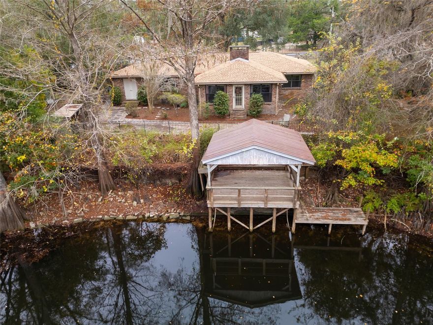 Discover serene riverfront living on the beautiful Withlacoochee River! This charming 2-bedroom, 2-bath home offers an inviting open floor plan with a cozy fireplace and a spacious Florida room perfect for year-round enjoyment. The large utility room provides abundant storage, making organization a breeze.  Step outside to your large covered dock with electric and water, ideal for boating, fishing, or simply relaxing by the water. Enjoy evenings around the fire pit.  Recent updates include a new roof (2022) and new AC (2025) for peace of mind. The property also features a carport designed for RV parking, making it perfect for adventurers or visiting guests.
Whether you’re looking for a full-time residence or a tranquil getaway, this riverfront retreat checks all the boxes!