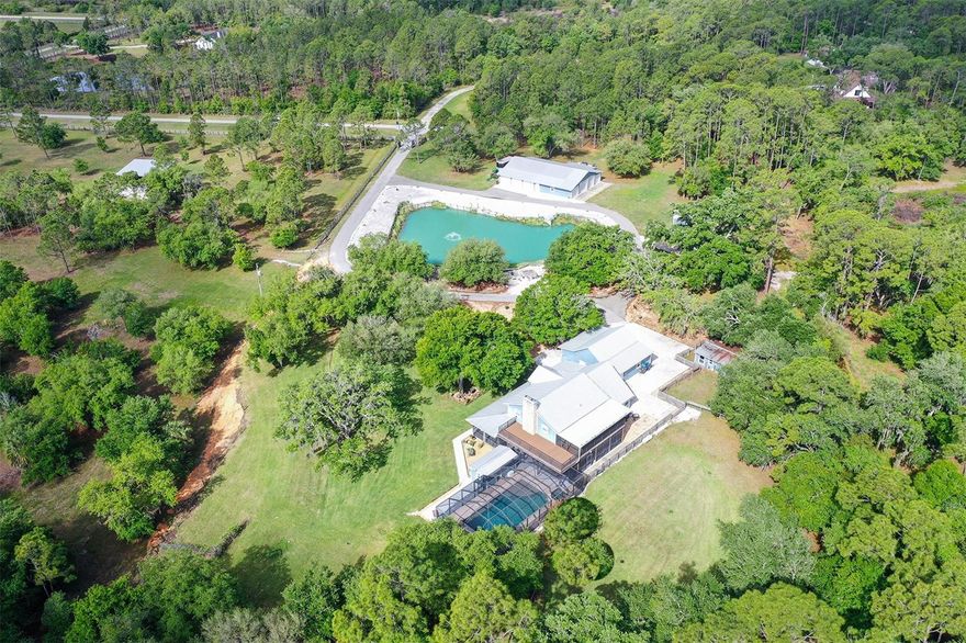 Nestled at the very end of a private road on 10 +/- acres in Panther Ridge, this stunning gated estate offers rare seclusion and luxury on a beautifully wooded lot with a serene lake and fountain centerpiece. Completely reconstructed inside and out with virtually brand-new everything, metal roofs on both the main residence and the 12+ Car Collector’s garage, Hardy Board siding, hurricane-rated doors and windows, all-new electrical (whole-house rewired), an impressive AC system with new duct work and 2 high-capacity units, and all-new plumbing. The entire property is fully fenced and cross-fenced, showcasing mature oak and pine trees. A custom wrought-iron staircase and stunning reclaimed oak and mahogany flooring pair beautifully with barn wood trim and accents throughout. Shiplap walls, knotty-pine accents, and plantation shutters complete the home’s signature look of quiet luxury. The gourmet kitchen features stainless steel appliances, a 6-burner Wolf gas range, quartz countertops and exceptional storage. Quartz counters continue in all bathrooms. Downstairs offers 2 spacious bedrooms including one huge 20 x 20 room that easily functions as a second primary, plus a Jack & Jill bath. Upstairs you’ll find the primary suite with a private screened L-shaped composite balcony, luxurious spa bath, and 21 x 14 walk-in closet, plus 2 additional guest bedrooms and guest bath. Outside, an expansive screened wrap-around porch on the first floor connects seamlessly to a resort-style heated saltwater 36 x 18 lap pool and 10-person spa, covered summer kitchen, and dramatic 2-story outdoor fireplace — the ultimate year-round entertaining space. Additional features include a laundry/mud room, upgraded Safetouch security system with dedicated cameras and internet, and in the downstairs primary a sound system with KEF speakers. Not to be missed-the oversized concrete block 3½-car garage (35 x 29) with RV hookup and future safe-room potential. Also on the property is a custom 15x20 combination of an a/c doghouse with runs and a brand-new, never-used state-of-the-art chicken coop. The true showpiece is the 4,464 sq ft. air-conditioned Car Collector’s Dream Garage (72 x 62) with 16-ft vaulted knotty-pine ceilings, rare sinker cypress feature wall, blue-vein knotty pine faux porch, gunmetal accents, custom stained concrete floors, car lift, 3 garage and 4 roll up doors, and RV hookup.  Imagine stepping into the Car Collector’s Dream Garage and feeling like you’ve entered a private automotive resort. Climate-controlled year-round, the 4,464 sq ft space features soaring knotty-pine ceilings that make every vehicle look like a museum piece, a dramatic rare sinker cypress feature wall, a blue-vein knotty pine faux porch perfect for relaxing with fellow enthusiasts, sleek gunmetal accents, and showroom-perfect custom stained concrete floors that are easy to clean yet incredibly durable. A professional car lift, 7 doors for effortless loading of trucks, boats or trailers, abundant LED lighting, a dedicated tool room with extra studs for customization, a large storage area, and an outside RV hookup completes this dream setup. Whether you’re restoring classics, detailing exotics, hosting car meets, or simply enjoying your collection in perfect comfort, this garage is built for serious enthusiasts who demand the very best. This is a true one-of-a-kind estate built for the discerning buyer who wants privacy, quality, and the ultimate car-collectors garage.