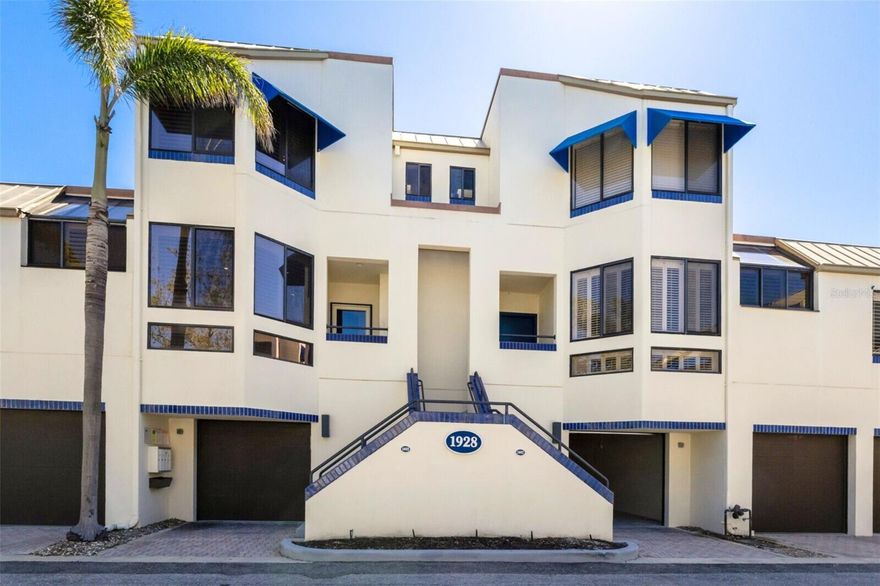 REDUCED PRICE! Are you looking for a RESORT home with spacious rooms, fine finishes, vaulted ceilings and the convenience of a condo community with bay and beach access? Look no further. Luxury and style await in this beautifully updated townhouse, located behind the gates of the exclusive Bay Isles resort. With 1,590 sq. ft. of meticulously designed and finished indoor living space plus another 1,100 sq. ft. of screened lanai, storage and garage space, this resort home provides the ultimate in luxe living, comfort and convenience. Upon entering this home, you're greeted by an open concept great room and designer kitchen, vaulted ceilings, a conveniently placed guest bathroom, and views over the very private community pool. You'll never want to leave! The gourmet kitchen is a chef’s dream, featuring gleaming granite countertops including a striking azure blue granite breakfast bar, custom mosaic glass tile backsplash, solid wood cabinetry, and stainless JennAir appliances. Easy to maintain luxury vinyl plank floors flow throughout, adding sophistication and durability. Soaring cathedral ceilings and abundant natural light enhance the light, bright, spacious feel of this home and the private screened lanai offers a serene retreat with access to lushly landscaped grounds and the resort style pool. The oversized primary suite boasts vaulted ceilings, a walk-in closet, and an elegant ensuite bath with natural stone and custom tile shower. The second bedroom also has a vaulted ceiling plus walk-in closet and beautifully finished adjacent bathroom. The ground-level garage has extra depth enabling covered parking for two cars plus there's a separate room that can be flexibly used for storage, a home gym, or a wine cellar. As a Bay Isles resident, you'll enjoy exclusive access to resident-only amenities including a private clubhouse, fitness center, heated pool and spa, tennis courts, and the private Bay Isles Beach Club. This resort home is just minutes from the vibrant dining, shopping, and cultural scene of St. Armands Circle and downtown Sarasota. See this home today and enjoy the best of Longboat Key living.