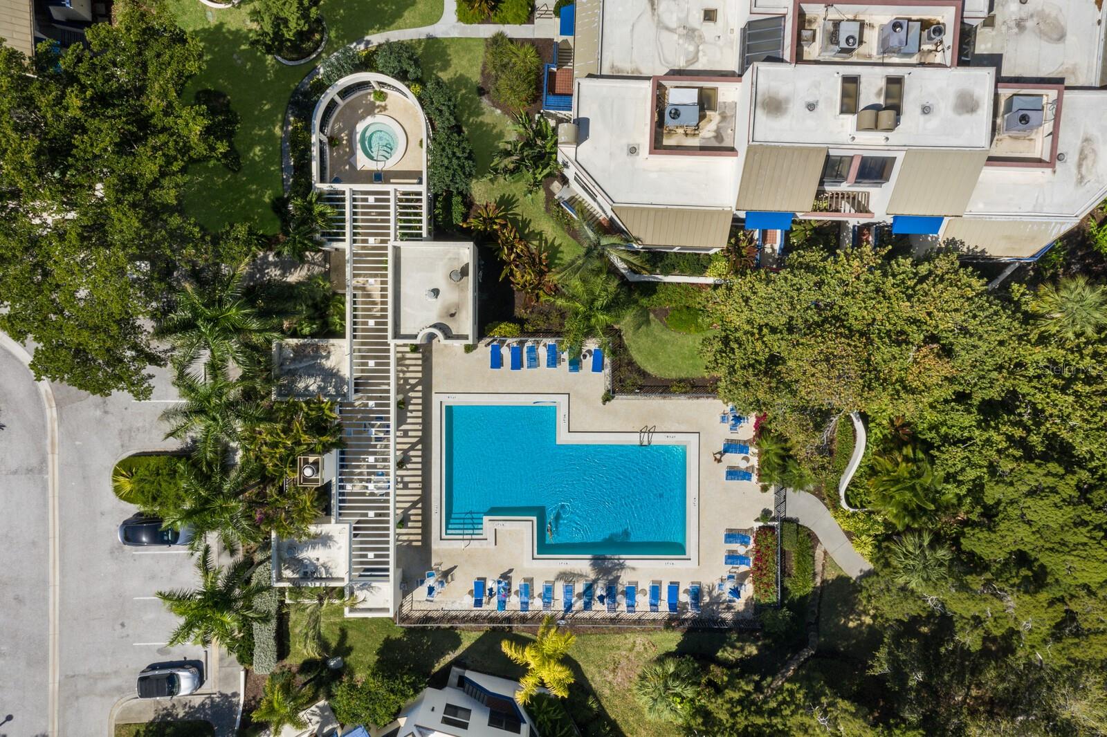 Are you looking for a spacious home with fine finishes, vaulted ceilings and the convenience of a condo community with bay and beach access? Look no further. Luxury and style await in this beautifully updated townhouse, located behind the gates of the exclusive Bay Isles resort. With 1,590 sq. ft. of meticulously designed and finished indoor living space plus another 1,100 sq. ft. of screened lanai, storage and garage space, this resort home provides the ultimate in luxe living, comfort and convenience. Upon entering this home, you're greeted by an open concept great room and designer kitchen, vaulted ceilings, a conveniently placed guest bathroom, partial bay views, and views over the very private community pool. You'll never want to leave! The gourmet kitchen is a chef’s dream, featuring gleaming granite countertops including a striking azure blue granite breakfast bar, custom mosaic glass tile backsplash, solid wood cabinetry, and stainless JennAir appliances. Easy to maintain luxury vinyl plank floors flow throughout, adding sophistication and durability. Soaring cathedral ceilings and abundant natural light enhance the light, bright, spacious feel of this home and the private screened lanai offers a serene retreat with access to lushly landscaped grounds and the resort style pool. The oversized primary suite boasts vaulted ceilings, a walk-in closet, and an elegant ensuite bath with natural stone and custom tile shower. The second bedroom also has a vaulted ceiling plus walk-in closet and beautifully finished adjacent bathroom. The ground-level garage has extra depth enabling covered parking for two cars plus there's a separate room that can be flexibly used for storage, a home gym, or a wine cellar. As a Bay Isles resident, you'll enjoy exclusive access to world-class amenities including a private clubhouse, fitness center, heated pool and spa, tennis courts, and the private Bay Isles Beach Club. This resort home is just minutes from the vibrant dining, shopping, and cultural scene of St. Armands Circle and downtown Sarasota. See this home today and enjoy the best of Longboat Key living.