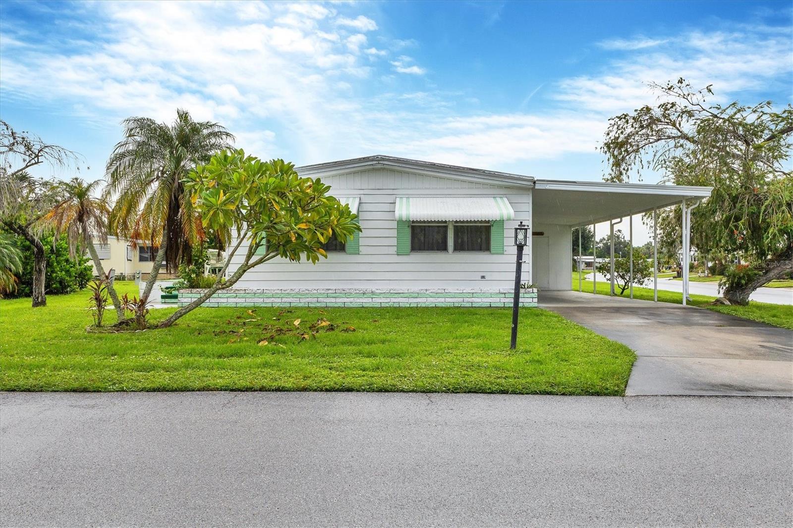 Welcome to your own little peace of paradise. This move in ready home is waiting for you to make it your own. It come partially furnished. Most of the furniture is staying including the bedrooms TV's tables etc. Shadow Brook is one of the best kept secrets in Manatee county. You own the land which means NO LOT RENT. The low quarterly fee includes Water, Sewer, Cable and Internet. It is a any age pet friendly park. Brand new AC installed in the fall of 2024. The lifetime roof was recoated and sealed with a five year warranty. Both bedrooms have a walk in and a built-in closet. This gives you plenty of space for your clothes. There is laminate flooring throughout the house except the kitchen which has linoleum. Shadow Brook features a beautiful heated pool and shuffle board courts. The clubhouse has a large library and a pool table. You can rent out the clubhouse for special events. Shadow Brook is located near the Sunshine Skyway Bridge and I 75. The beautiful gulf beaches of Anna Maria Island are just a short drive away. All room sizes are approximate. Please use As Is contract.