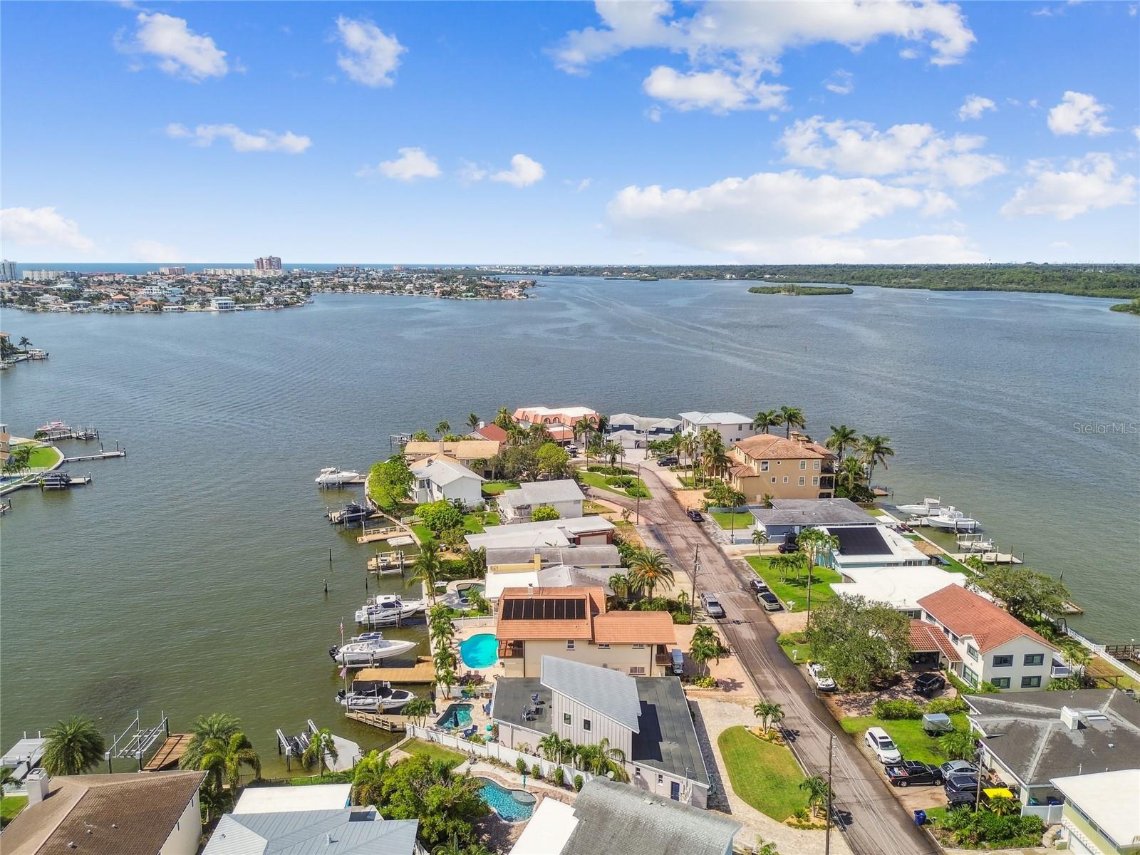 Coastal waterfront luxury home just steps from Redington Beach | 3,000-plus square feet | fully renovated (2025). This stunningly renovated, move-in-ready three-bedroom, three-bath waterfront home blends luxury, space and functionality with thoughtful coastal vibe upgrades. Featuring an open-concept layout, designer kitchen, expansive living spaces, custom built-in shelving, and a private upstairs primary retreat with panoramic water views. Enjoy a heated saltwater pool, outdoor kitchen-ready gas setup, and composite dock with 7,000-pound lift. Major upgrades include full downstairs reno (2025) plus upstairs addition (2016). Pavers, retaining seawall, saltwater pool, gas lines (2017–2018.) New entry doors, roof (2021–2023). New Trane HVACs, floors, pool heater and pump (2024–2025). Custom closets (2022). Natural gas generator. Enter the spacious great room, featuring lots of natural sunlight, plantation shutters, barn doors and wood-accented ceilings. The open-concept kitchen boasts quartz countertops, stainless appliances, a large island, exposed beams and designer tile. A bright, expansive family room offers flexible living and dining space with abundant natural light and a fireplace for ambiance. The main level includes two full baths and two guest bedrooms—one with a renovated en-suite bath—plus a cozy den with a custom bar and wine refrigerator. A large bonus room can serve as a fourth bedroom, home office, gym, storage or convertible garage. A beautifully updated interior laundry room and third full bath round out the first floor. Upstairs, the luxurious primary suite features vaulted ceilings, wood beam accents and a four-panel sliding glass door overlooking the water. The spa-like en suite includes a spacious walk-in shower, jetted tub, private water closet and modern double vanity. Plenty of space in the custom walk-in closet too! The primary suite opens to a gigantic rooftop deck with panoramic views and lots of expansion potential to increase interior or exterior space. Add more bedrooms or finish out for a glorious panoramic rooftop deck. The backyard is an entertainer’s dream with a heated saltwater pool, outdoor shower, extensive paver decking, a large motorized retractable awing provides shade to relax poolside in the heat of the day, and gas connections for grills and equipment. The composite dock includes water, power, and a 7,000-pound lift for boating enthusiasts. All this just a short distance to the powdery sands of Redington Beach, minutes to fine dining, shopping, downtown St Pete and only 40 minutes to Tampa International Airport. Whether you’re looking for a full-time residence or luxury vacation home, this turnkey property delivers coastal living at its finest.