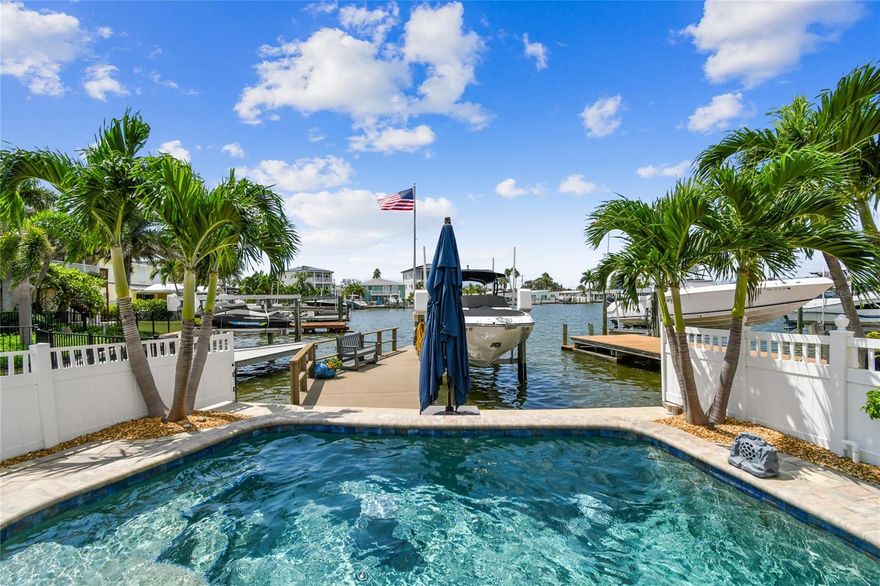 SIGNIFICANT $$ PRICE IMPROVEMENT!!!  Coastal waterfront luxury home just steps from Redington Beach | Over 3,000 square feet | fully renovated (2025). This stunningly renovated, move-in-ready 3-4 -bedroom, 3-bath waterfront home blends luxury, space and functionality with thoughtful coastal vibe upgrades. Featuring an open-concept layout, designer kitchen, expansive living spaces, custom built-in shelving, and a private upstairs primary retreat with panoramic water views. Enjoy a heated saltwater pool, outdoor kitchen-ready gas setup, and composite dock with 7,000-pound lift. Major upgrades include full downstairs reno (2025) plus upstairs addition (2016). Pavers, retaining seawall, saltwater pool, gas lines (2017–2018.) New entry doors, roof (2021–2023). New Trane HVACs, floors, pool heater and pump (2024–2025). Custom closets (2022). Natural gas. Enter the spacious great room, featuring lots of natural sunlight, plantation shutters, barn doors and wood-accented ceilings. The open-concept kitchen boasts quartz countertops, stainless appliances, a large island, exposed beams and designer tile. A bright, expansive family room offers flexible living and dining space with abundant natural light and a fireplace for ambiance. The main level includes two full baths and 2-3 guest bedrooms—one with a renovated en-suite bath—plus a cozy den with a custom bar and wine refrigerator. A large bonus room can serve as a fourth bedroom, home office, gym, storage or convertible garage. A beautifully updated interior laundry room and third full bath round out the first floor. Upstairs, the luxurious primary suite features vaulted ceilings, wood beam accents and a four-panel sliding glass door overlooking the water. The spa-like en suite includes a spacious walk-in shower, jetted tub, private water closet and modern double vanity. Plenty of space in the custom walk-in closet too! The primary suite opens to a gigantic rooftop deck with panoramic views and lots of expansion potential to increase interior or exterior space. Add more bedrooms or finish out for a glorious panoramic rooftop deck. The backyard is an entertainer’s dream with a heated saltwater pool, extensive paver decking, a large motorized retractable awing provides shade to relax poolside in the heat of the day, and gas connections for grills and equipment. The composite dock includes water, power, and a 7,000-pound lift for boating enthusiasts. All this just a short distance to the powdery sands of Redington Beach, minutes to fine dining, shopping, downtown St Pete and only 40 minutes to Tampa International Airport. Whether you’re looking for a full-time residence or luxury vacation home, this turnkey property delivers coastal living at its finest.
