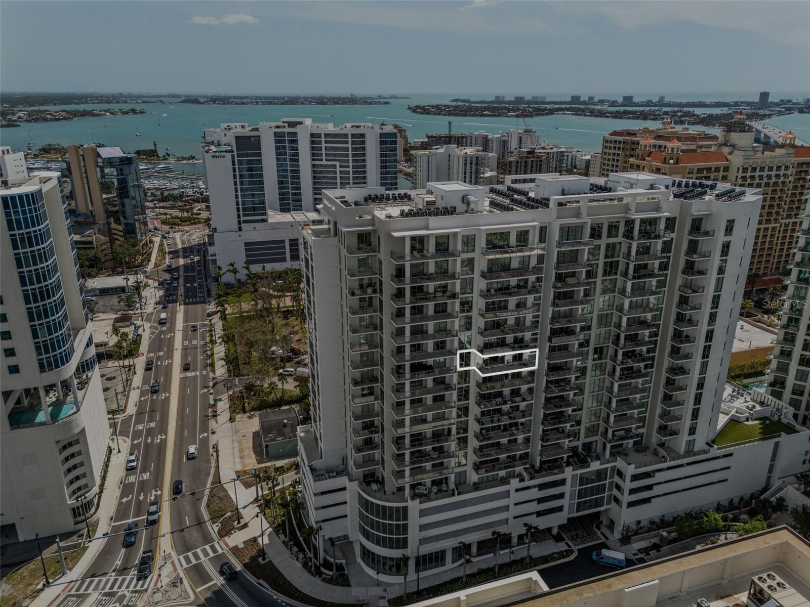 MOTIVIATED SELLER! BRING ALL OFFERS!!! THE PERFECT OPPORTUNITY TO OWN A NEWER LUXURY CONDO BUILT IN DOWNTOWN SARASOTA’S PREMIER WATERFRONT DISTRICT: View Property Video at this link: https://motion-media-llc.aryeo.com/videos/019646ef-fae1-7365-bff1-0b4149573426 | Welcome to BAYSO, where luxury meets the dynamic energy of Downtown Sarasota in an exclusive waterfront setting. This stunning 12th-floor residence offers a front-row seat to the transformation of The Quay, Sarasota’s most anticipated new destination. Here, you’ll experience an elevated lifestyle that seamlessly blends modern sophistication, breathtaking views, and the finest urban conveniences—all just steps from the shimmering waters of Sarasota Bay and the Yacht Harbor. UNPARALLELED DESIGN & SOPHISTICATION | This meticulously designed 2-bedroom + den, 3-bathroom residence is a masterpiece of form and function. Expansive 10-foot floor-to-ceiling windows bathe the open-concept living spaces in natural light, creating a seamless connection between the luxurious interiors and the breathtaking city and bay views. A private terrace offers a serene escape, perfect for savoring sunrise to the east or the dazzling lights of downtown in the evening.
At the heart of the home, the chef’s kitchen is an entertainer’s dream. Outfitted with top-tier appliances by JennAir, European custom cabinetry by Italkraft, and sleek quartz countertops, it delivers both style and performance. Whether hosting intimate gatherings or preparing a quiet meal at home, this space embodies modern elegance. The primary suite is a private sanctuary, offering a tranquil retreat with spa-inspired finishes, a lavish ensuite bathroom, and generous closet space. The secondary bedroom is equally well-appointed, providing guests with comfort and privacy. Meanwhile, the versatile den serves as a home office, media lounge, or even a third sleeping area—tailored to your lifestyle needs. Two assigned parking spaces are in a secure and elevated garage in a premium location which complete this exceptional offering. LIVE AT THE CENTER OF SARASOTA’S FUTURE | Beyond the walls of this exquisite home, The Quay is evolving into the new epicenter of luxury living in Sarasota. A meticulously planned waterfront district, it will feature world-class dining, high-end boutiques, cultural attractions, along with a redesigned Yacht Harbor, all just moments from your doorstep. Whether you’re setting sail for a day on the water, enjoying a performance at the Sarasota Opera House, or indulging in the renowned culinary scene, everything you desire is within reach.
This is more than a residence—it’s an opportunity to be part of Sarasota’s most exciting transformation. Don’t just watch the evolution of The Quay—secure your place in it. Schedule your private showing today.