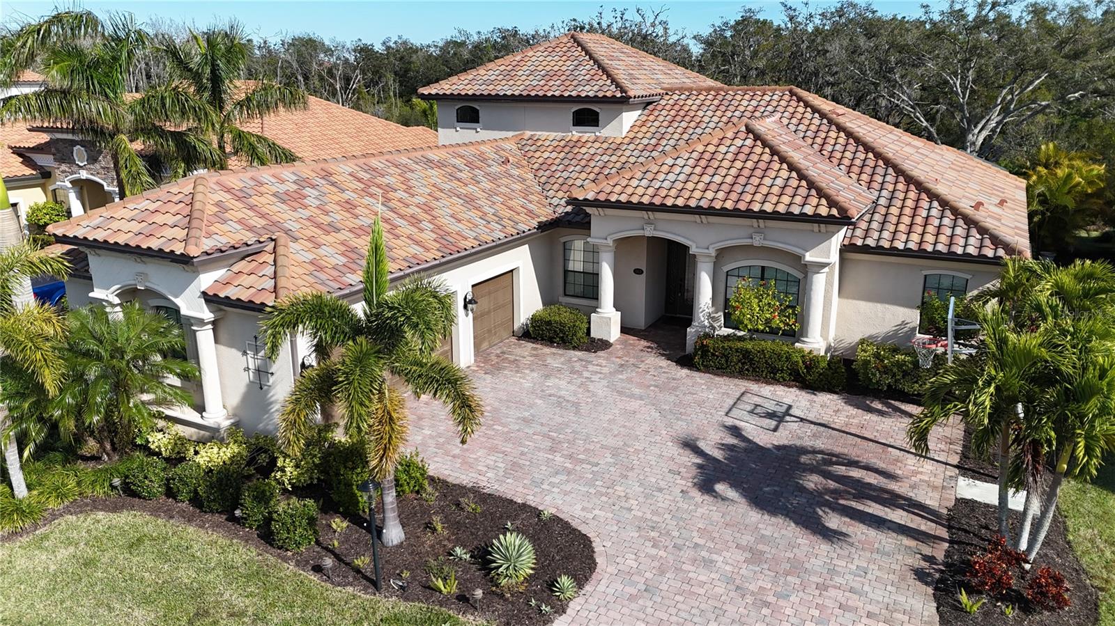 Experience refined Florida living in this stunning Cambridge Grande model, nestled within the gated community of Bridgewater. This 4-bedroom, 4-bath home offers thoughtful design, timeless finishes, and serene views of the pool and wooded preserve.
Step inside to a bright and inviting great room with ceramic tile floors, built-in bookcases, and seamless views of the lanai and preserve. The gourmet kitchen is a chef’s dream, featuring rich mocha cabinetry, gleaming quartz countertops, stainless steel appliances, and a cozy eat-in area perfect for morning coffee. A formal dining room at the front of the home provides the perfect setting for entertaining.
The spacious primary suite, located on the main level, is a private retreat with direct pool and spa access. The spa-like bath features dual sinks, granite countertops, wood cabinetry, soaking tub, and a walk-in shower. Two additional bedrooms and a versatile den/office to complete the first floor.
Upstairs, discover a large bonus room with full bath—ideal for entertaining or accommodating guests. A custom wet bar with cabinetry, granite counters, beverage fridge, and stainless sink makes hosting effortless.
Outdoor living shines on the expansive screened lanai with heated pool and spa, multiple seating areas, and peaceful preserve views. A three-car side-entry garage adds both function and curb appeal.
Perfectly located near Lakewood Ranch’s vibrant amenities, I-75, University Town Center Mall, Benderson Park, and the Sarasota/Bradenton airport, this home combines elegance, comfort, and convenience.