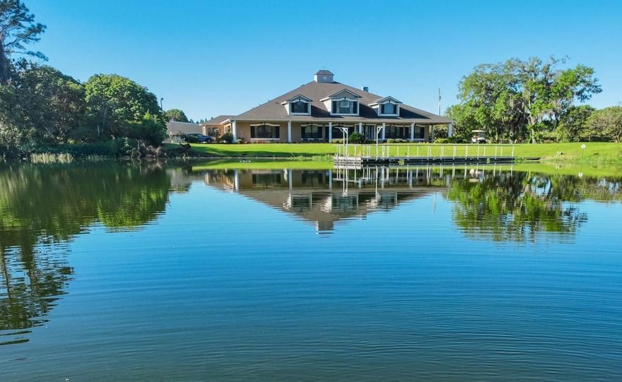 One or more photo(s) has been virtually staged. As you pass through the gates of this beautiful, 52.24-acre legacy estate, a long winding road lined with blooming azaleas, mature lychee trees, and all the natural beauty of old Florida begins to unfold itself everywhere you look. The property's focal point is a majestic, seven-acre lake, only steps from the front door. It's the ideal spot for your morning coffee, to fish the afternoon away, or to catch a stunning sunset at the end of the day. This custom, two-story 9349sf home boasts a wrap-around porch, four spacious bedrooms, and five baths. The expansive primary kitchen was created with family gatherings in mind. It includes Thermador appliances, double ovens, a warming drawer, two sinks, a large center island, illuminating lead-glass door cabinetry, plenty of bar seating, and a walk-in butler's pantry with custom features. The secondary kitchen is located right off the sunroom, it offers a gas range and wine fridge as well as easy access to the screened-in pool and spa. The oversized master bedroom has an adjacent private workout room with a wet bar and lake views.  The ensuite bath has separate water closets and custom dressing rooms. Other notable features of the home include a large custom laundry, built-in vacuum system, skylight roofing, four sets of sliding pocket doors, which allow you to expand your indoor and poolside living spaces. The property also includes a 5000sf metal barn with a loft, two bays, and an additional office and a half bath, a 105kw Generac generator, a 12” 675’ deep well for farm irrigation. Mature exotic fruit trees (lychee, avocado, mango, banana & pomelo grapefruit) are a special treat. The location of this one-of-a-kind Plant City property lies conveniently off of State Road 60 between Brandon and Lakeland. It has 1,428 feet of road frontage and three ingress and egresses. It is 10 miles to Lakeland International Airport and 16 miles to either I-4 or I-75 for commutes.