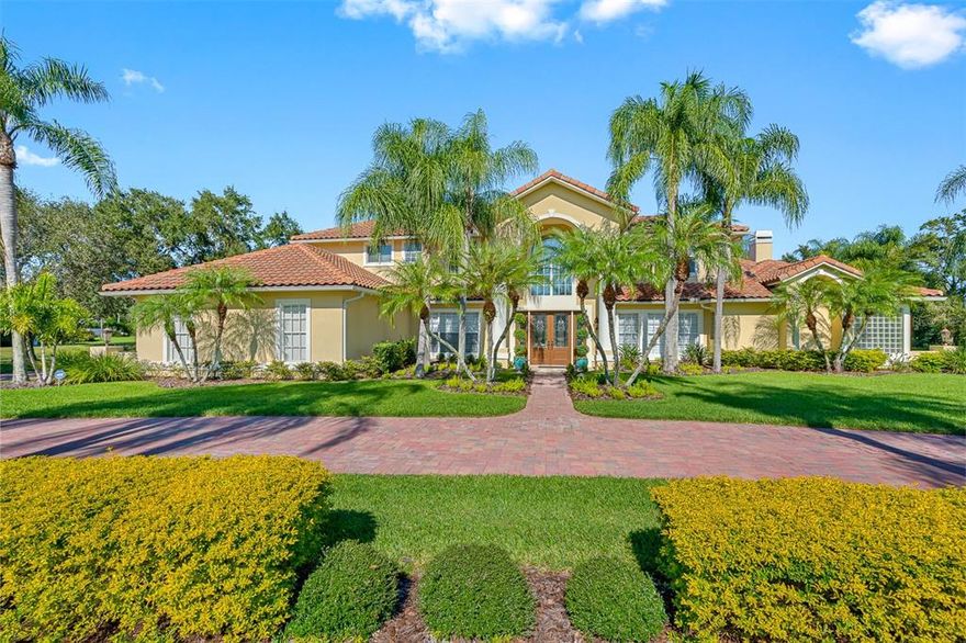 Celebrate the American traditional architectural style home with splashes of Mediterranean and Contemporary design throughout this custom estate home. This unique home sits on a spectacular waterfront lot in the prestigious gated golf course community of Cheval. Delight in the custom upgrades in the 5,786 square foot home with 5 bedrooms, 5 bathrooms, 2 half baths, 2 Bonus rooms, an office, and more! Enter through the leaded glass double front doors to the grand circular wood and wrought iron stairway in the expansive foyer. Travertine floors throughout the first floor, with carpet in the master suite area. The generous formal dining room has a custom tray ceiling and crown molding. The formal living room with double French doors to the patio and a transom window above with 20+ ft ceilings - providing great natural lighting. Stately office/study with mahogany wood built-ins - coffered ceiling - French doors for privacy.  Enter the master suite with an additional bonus room - an expansive master bedroom with a fireplace and French doors to the outside patio. The master bathroom has upgraded custom wood vanities with marble countertops, dual sinks, a separate vanity, a travertine seamless shower, Whirlpool jetted tub, Kohler hardware, crown molding, and a glass block privacy window. The master suite has two walk-in closets that are complete with custom closet systems. The kitchen was completely renovated with custom wood cabinetry, quartz countertops, glass subway backsplash, and stainless steel Thermador appliances which include a built-in refrigerator, gas stove with hood, double ovens, microwave, and wine refrigerator. Center island with storage, plenty of cabinets and counter space, and a walk-in pantry. The kitchen opens onto the gathering room, making this a great entertaining space. The gathering room has 20+ ceilings with crown molding and a double row of windows for wonderful natural light. There is a gas fireplace and built-in TV on the stone wall, plus custom built-ins. This room opens to the outside lanai and pool area. The first floor has an ensuite guest room which would make a great in-law suite. The bath has crown molding, a travertine seamless glass walk-in shower, a custom vanity with quartz countertop, decorative mirror, and lighting. The pool bath is accessible from the hallway for guests and the extra bonus room - complete with custom vanity, marble countertops, steam shower with marble walls, and a pebble floor.  Upstairs has wood floors throughout except all bathrooms have marble flooring.  The main bonus area with a bar and TV, plus half bath - makes a great place for kids to hang out. Two guest bedrooms share the Jack and Jill bathroom and an additional guest ensuite is upstairs. All bathrooms upstairs have custom vanities with marble countertops, walk-in seamless glass showers, and custom closets in each room. The outdoor covered lanai and pool with rock gas-heated spa.  Oversized covered lanai which overlooks the lake.  The outdoor area is pre-wired and pre-plumbed for the kitchen area. Massive 4-car garage with storage cabinets. Cheval has a private golf and country club for membership. The TPC golf course is also a membership club. Cheval is conveniently located to shopping, restaurants, and medical.  Access to the Veteran's Expressway to get to the Tampa International Airport, International Mall, downtown Tampa and St. Petersburg, all sporting venues, and the sandy white beaches of Florida's gulf coast. Room Feature: Linen Closet In Bath (Primary Bathroom).