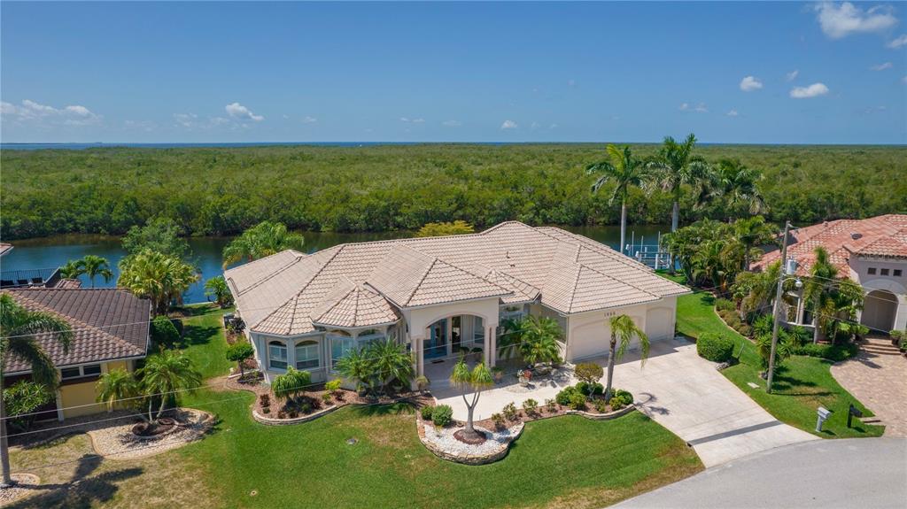 Not many come along of this caliber & location. Original owners are desiring to sell this 3727 sq. ft., 4-5 bedroom plus all purpose room, 3 and half bath, 3 car garage home capped off by over 750 sq. ft. of lanai(60 feet long!). This rim canal section 12 beauty has the desirable southern exposure for the pool overlooking 133 feet of city maintained seawall with concrete dock and oversized lift(16K lb. per owner). 4 sections of sliding glass doors for extremely nice water views and all of the boating traffic including the annual Christmas parade. Due to the canal being wider/lot width longer, you are able to dock almost any vessel(have a 100 foot yacht, no problem) including multi hull sailboats(catamarans) or have 2 lifts if desired. The 2nd bedroom has a full bath along with a 15x18 all purpose room. 2 color all wood kitchen cabinetry with awesome granite work that includes full backsplash. Breakfast nook has the enjoyable aquarium glass to "take it all in". Master suite is roughly 800 sq. ft. of luxury. Florida Power & Light "Buildsmart" medallion near front door due to low electricity bills. Pool and spa have solar and propane back up along with remote panel inside. Extensive landscaping, stamped drive and walkways accentuate the property. 10 minute access to Alligator Creek/Charlotte Harbor via Buckleys Pass or a little longer going out through Ponce Inlet.