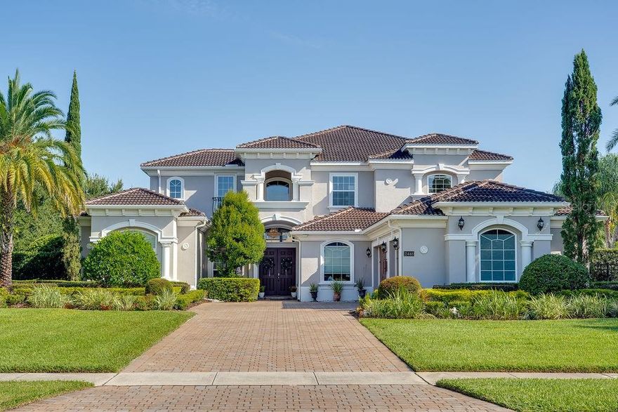 Under contract-accepting backup offers. This exceptional Florida residence is perfectly sited on an acre within the exclusive guard-gated community of Bellaria. Thoughtfully designed to balance sophistication with comfort, the home welcomes you with an abundance of natural light streaming through broad front windows, highlighting the elegant handcrafted staircase in the foyer. The formal living and dining areas set the tone for refined entertaining, enhanced by a gas fireplace, a well-appointed wet bar, and expansive views of the sparkling pool and two-story covered porch. Just off the entry, the study provides an intimate retreat with porcelain flooring and clerestory windows, filling the space with natural light and framing serene outdoor vistas. The open-concept family room and kitchen create the heart of the home, where a wall of glass doors seamlessly blends indoor and outdoor living. The gourmet kitchen is a chef’s delight, featuring stainless steel appliances, exotic granite, custom cabinetry, tile flooring, and a spacious walk-in pantry. The first-floor master suite, thoughtfully tucked away for privacy, serves as a true sanctuary. Its spa-inspired bath is adorned with paneled cabinetry, exotic granite, a rainforest shower, soaking tub, and expansive closet areas—both beautiful and functional. Two additional en suite guest bedrooms, a versatile bonus room, and generous living and dining spaces make the main level ideal for everyday living or hosting. Upstairs, the thoughtful layout continues with three bedrooms, a loft, a sitting area, a bonus room, and even a second laundry room for added convenience. These flexible spaces adapt easily to the needs of a growing family or guests, offering opportunities for work, play, or relaxation. Blending elegance with livability, this home captures the essence of Florida living—where interiors open gracefully to resort-style outdoor spaces, making it perfect for both intimate family life and grand entertaining.