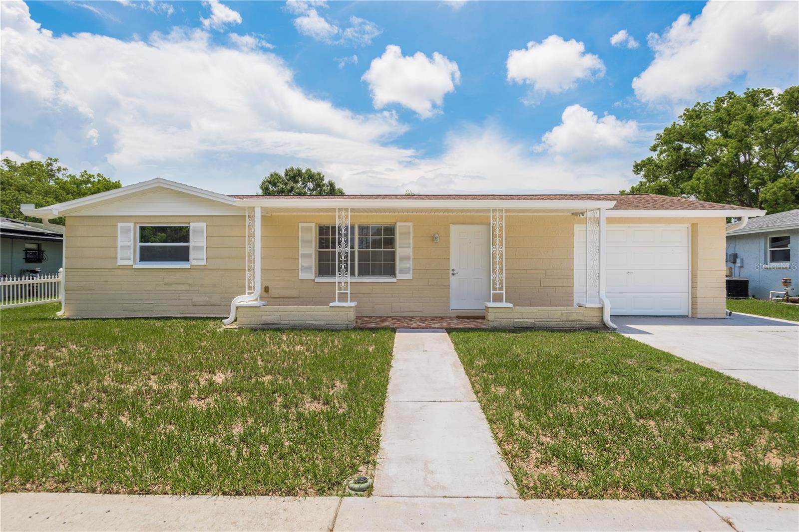 Don’t miss this opportunity to rent a beautiful move-in-ready home just north of Tarpon Springs. 5646 Festivo Drive is a fully updated three-bedroom, two-bathroom home with a one-car garage located in the quiet La Villa Gardens neighborhood. Arriving at the home, you will notice the covered porch with brick pavers to welcome you inside. Upon entering, the spacious living room is filled with natural light and is perfect for any furniture configuration. Updated luxury vinyl plank flooring and freshly painted walls throughout! Head through the hall into the modern, white kitchen, which features all stainless-steel appliances, granite countertops, shaker-style cabinets, and an over-the-sink view out to the backyard. On the east side of the home are the primary bedroom and a guest bedroom, both of which feature sizable closets. Just outside these rooms is the fully renovated main bathroom, featuring an updated vanity, brushed nickel fixtures, and a tiled tub/shower combo. On the opposite side of the home is an additional bedroom, perfect for guests or an office with access to a private enclosed sunroom. Both of these rooms overlook the oversized, fenced-in backyard. Back inside, just off the 3rd bedroom, is another guest bathroom, also fully updated, with a tiled walk-in shower. Additionally, in the garage is a large space for a washer and dryer. The residence is conveniently located near major highways, medical facilities, and grocery stores. Stunning beaches and parks are close by, and Tampa International Airport is just a 35-minute drive away.