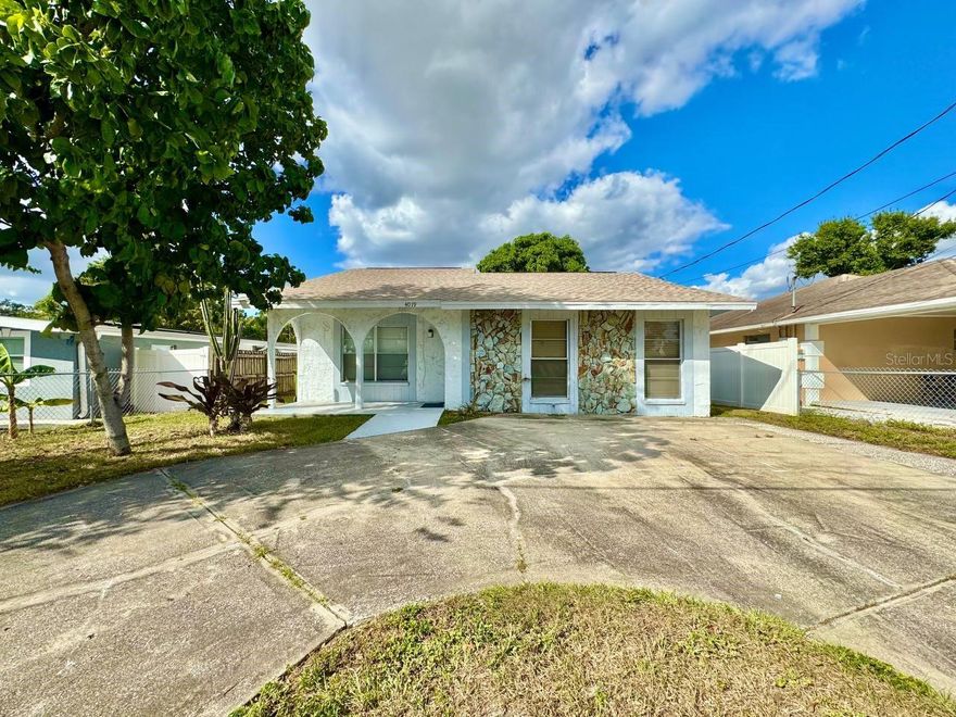 Welcome to this beautifully preserved 3-bedroom, 2-bath vintage gem located in the heart of Belvedere Park just minutes from Tampa International Airport, International Plaza, and the new Midtown Complex. Step into the inviting foyer, which opens into a spacious sunken living room featuring plush carpeting and expansive floor-to-ceiling windows that flood the space with natural light. Neutral tones throughout provide a perfect backdrop for your personal style. Enjoy meals in the separate dining area with serene views of your privately fenced backyard oasis. The compact yet efficient kitchen features ample cabinet and counter space, along with a convenient built-in breakfast bar perfect for casual dining or catching up over weekend plans. The thoughtfully designed split-bedroom floor plan includes a massive primary suite with its own private entrance to the backyard, a walk-in closet, and an en-suite bath with a standalone shower. The two additional bedrooms are generously sized, each with large closets, and share a well-appointed full bathroom. One bedroom is ideal as a guest room, home office, playroom, or media space. Outside, mature landscaping and decorative steppingstones create a peaceful and inviting outdoor space perfect for relaxing or entertaining. A circular driveway offers ample parking for up to three vehicles, and the dedicated laundry room includes a washer and dryer for your convenience. Located just moments from I-275 (no traffic lights between you and the interstate!), downtown Tampa, shopping, dining, and more this home offers the perfect blend of vintage charm and unbeatable location. In addition to the advertised base rent, all residents are enrolled in the Resident Benefits Package (RBP) for $50.00/month which includes HVAC air filter delivery, credit building to help boost your credit score with timely rent payments, utility concierge service making utility connection a breeze during your move-in, and much more! More details upon application. One pet welcome, 20 lbs max. Vacant and Available now.
